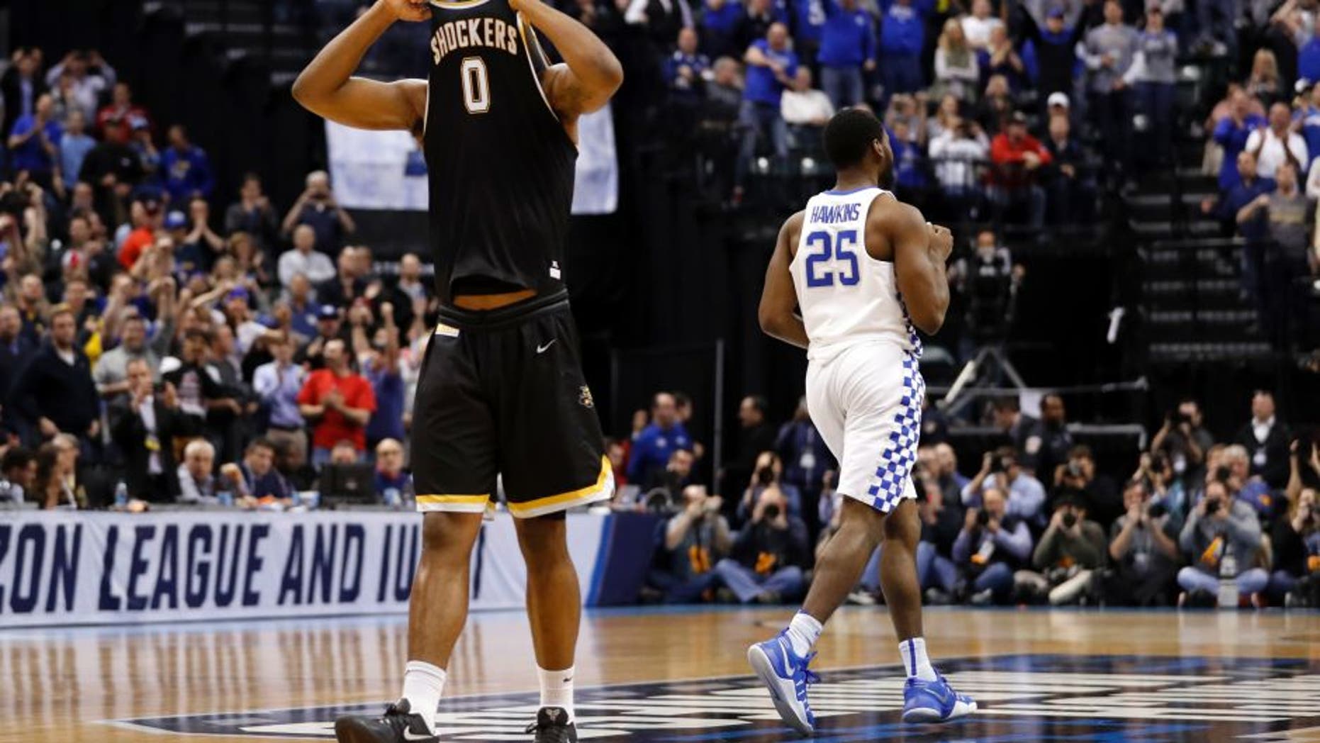 Wichita State's Rashard Kelly (0) hides his face as Kentucky's Dominique Hawkins (25) heads to celebrates with his teammates following a second-round game in the men's NCAA college basketball tournament Sunday, March 19, 2017, in Indianapolis. Kentucky won 65-62. (AP Photo/Jeff Roberson)
