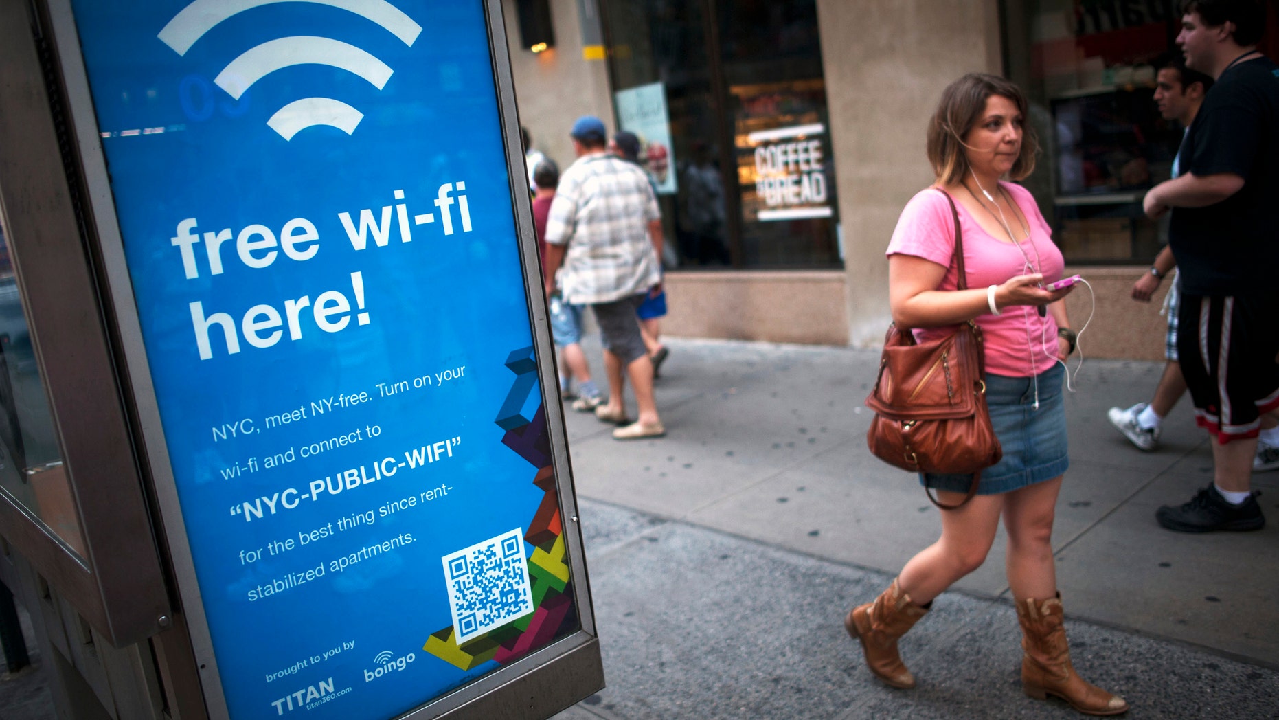 A woman walks past a WiFi-enabled phone booth in New York.