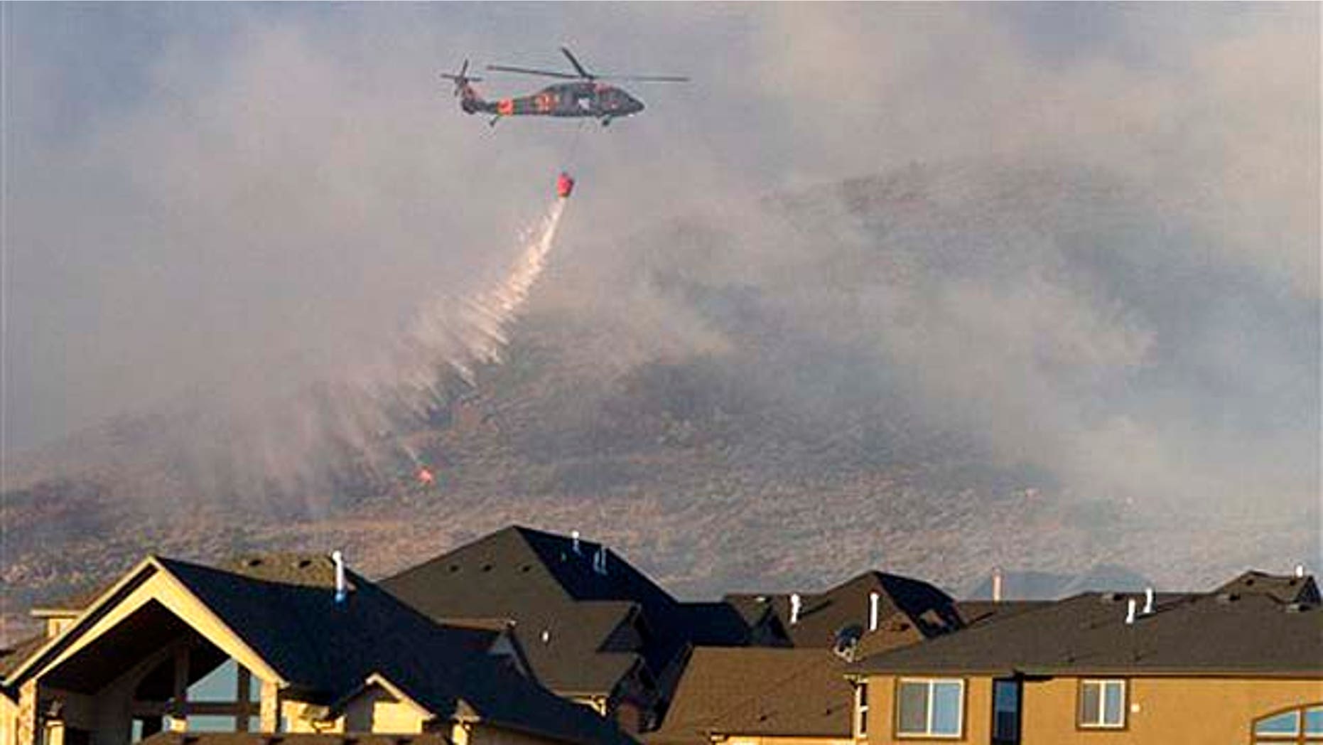 Sept. 20: A helicopter is used to drop water on the wildfire that burns in the foothills of Herriman, Utah. A wind-stoked wildfire sparked at a firing range during a National Guard training session blazed across thousands of acres Monday as crews rushed to keep it from burning more than four homes that were destroyed overnight. The fire moved back on itself Monday as the Utah National Guard acknowledged it wasn't the first time that live-fire exercises had sparked a fire at Camp Williams, a sprawling compound 30 miles south of Salt Lake City.