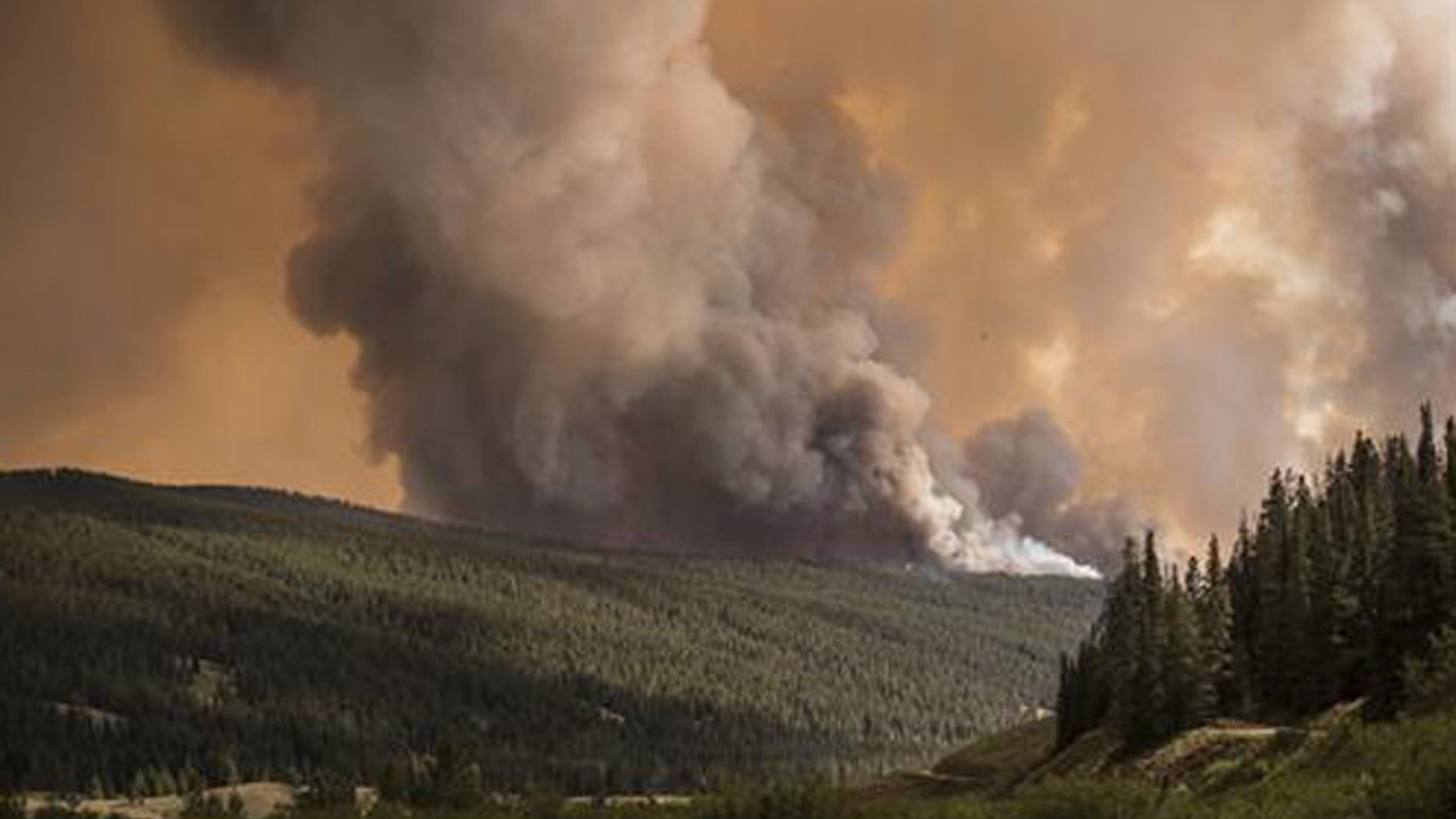 In this Monday, July 18, 2016, photo, smoke plumes from the top of the ridge above Granite Creek on the Bridger-Teton National Forest north of Bondurant, Wyo.