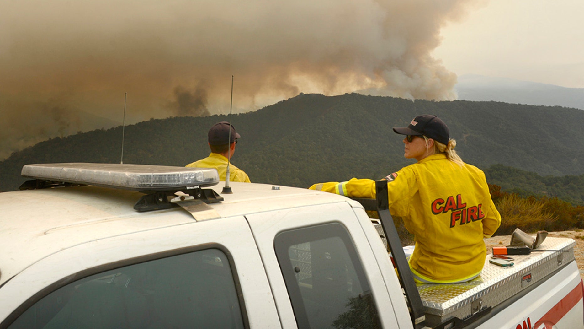 Aug. 1, 2016: Firefighters keep a lookout from Sky Ranch off Cachagua Grade as smoke and flames from a back burn light up a ridge to the south in east Carmel Valley, Calif.