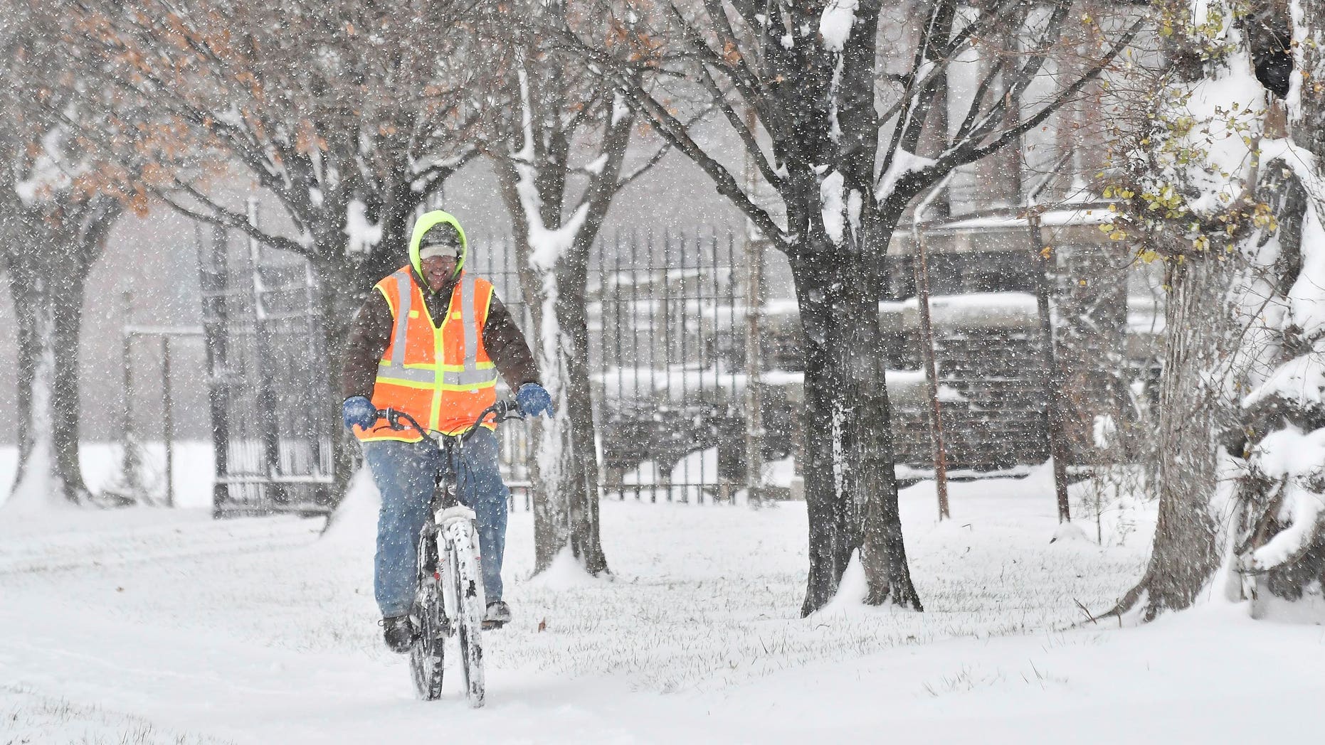 Jacinto L. Santos makes his way through the snow on his bicycle in Detroit, Sunday, Dec. 11, 2016. Santos, originally from Texas, said his mountain bike is his main mode of transportation to work and everywhere. Much of Michigan's southern Lower Peninsula, from Lake Michigan to Lake Huron, is under a winter storm warning. (Robin Buckson/Detroit News via AP)