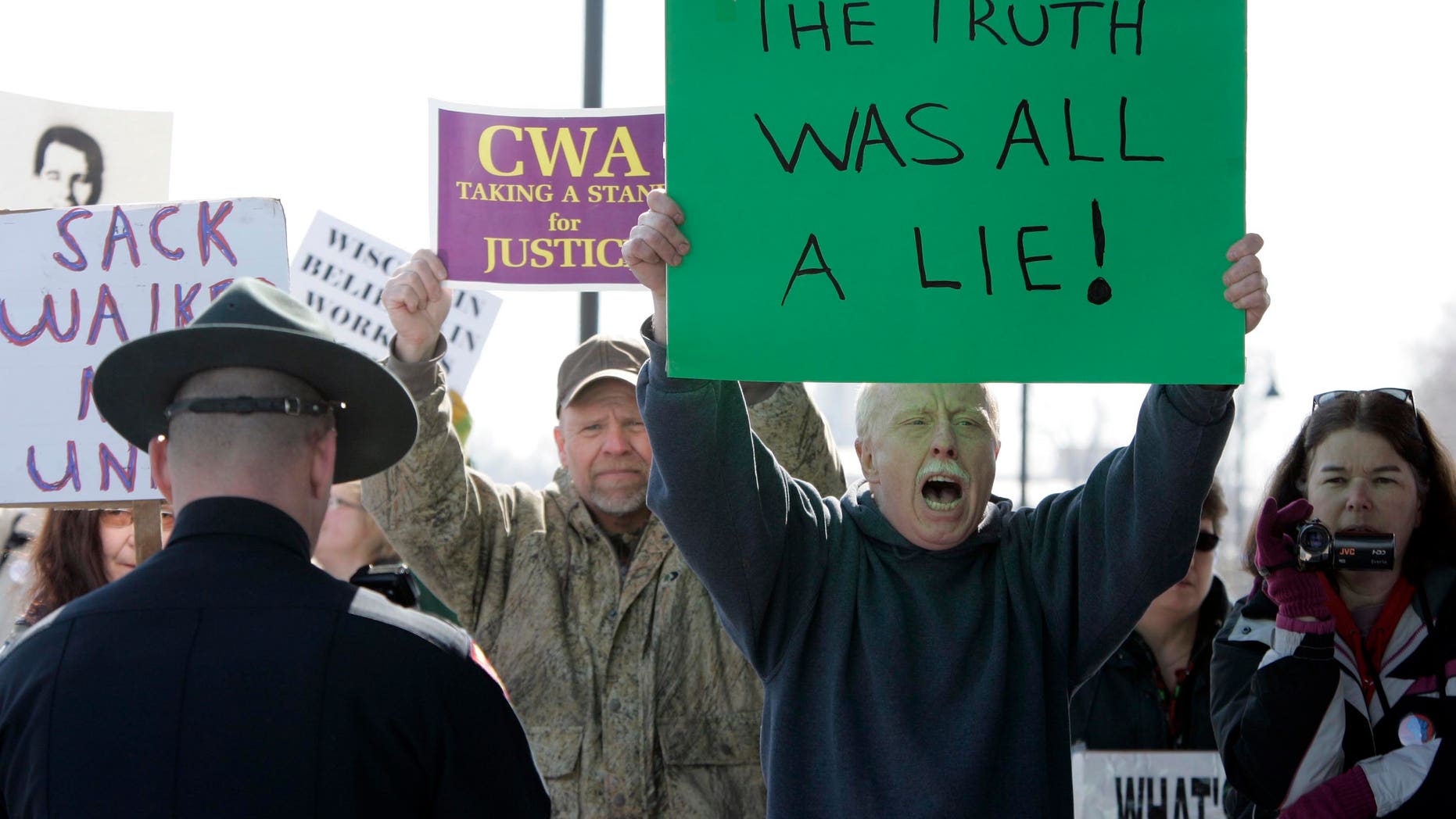 Dan Schierl of Neenah, Wis., second from right, joins other protesters during Gov. Scott Walker's announcement from the Fox Cities Trestle Trail over Little Lake Butte Des Morts Thursday, March 31, 2011 in Menasha, Wis. (AP)