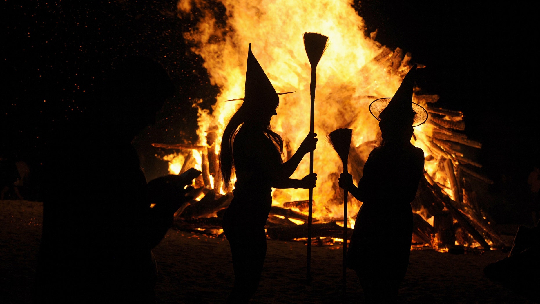 File photo: Two women dressed up as witches take pictures in front of the bonfire during the traditional San Juan's (Saint John) night on the beach in Gijon, northern Spain, June 24, 2015. (REUTERS/Eloy Alonso TPX)