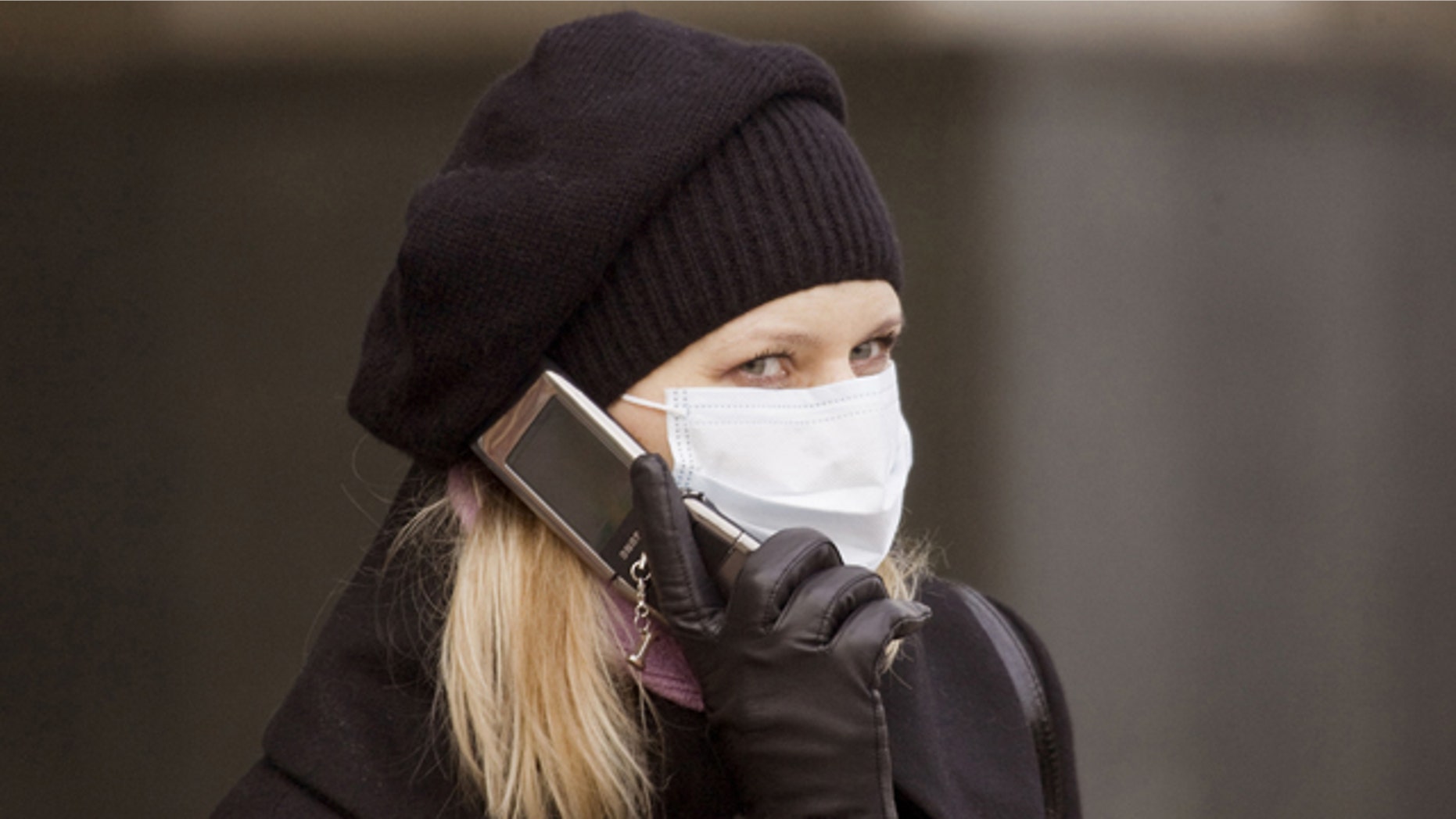 A woman wearing protective mask talks on the phone in Lviv, October 31, 2009. Ukrainian authorities cancelled all the presidential election campaign activities for three weeks because of a ban imposed on mass events after the H1N1 virus had been found among diseased Ukrainians, local media reported. REUTERS/Vasily Fedosenko (UKRAINE HEALTH SOCIETY IMAGES OF THE DAY)