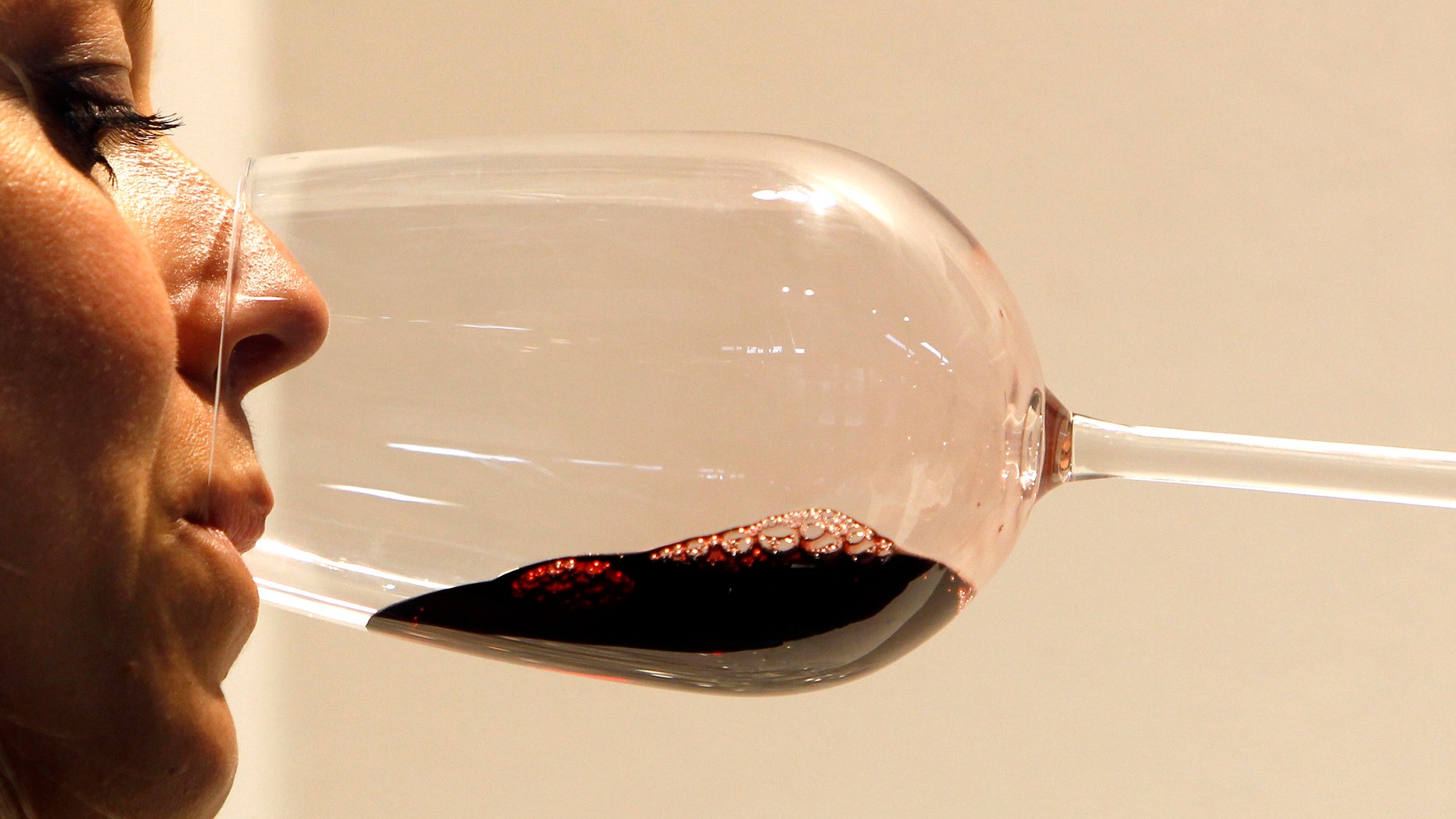 A woman tests a glass of red wine during the Vinitaly wine expo in Verona, April 8, 2011. China, Russia and Brazil where consumers are discovering a pleasure of drinking good wine, will power growth of Italy's wine export while the core U.S. market recovers after crisis, industry experts say. Wine exports from Italy, which competes with France for the position of the world's biggest producer, rose about 11 percent to 3.9 billion euros ($5.62 billion) in 2010, according to industry data, as markets recovered from the global downturn. REUTERS/Stefano Rellandini ( ITALY - Tags: FOOD BUSINESS)