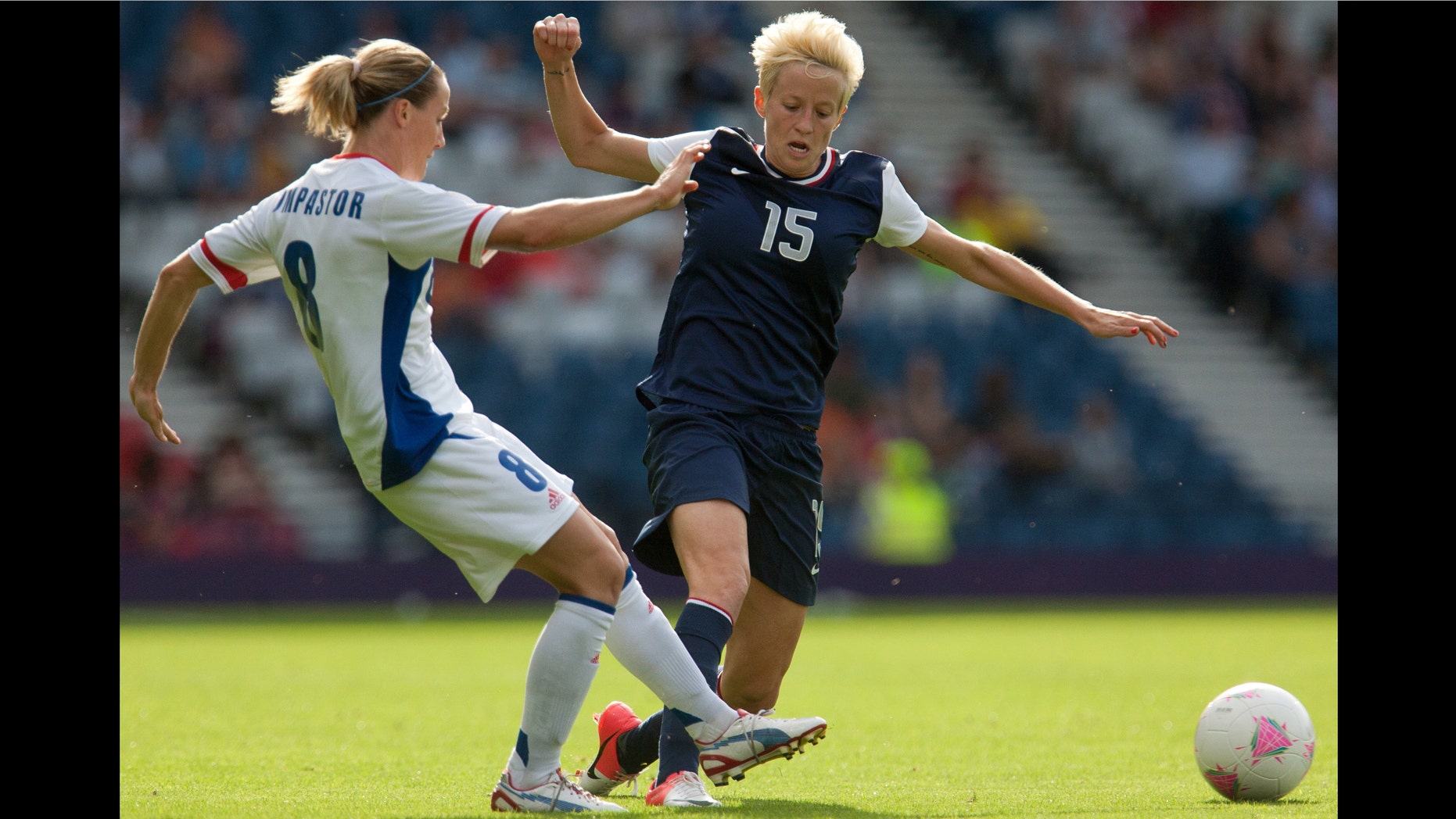 France's Sonia Bompastor, left, vies for the ball with United States' Megan Rapinoe during the women's group G soccer match between the United States and France at the London 2012 Summer Olympics, Wednesday, July 25, 2012, at Hampden Park Stadium in Glasgow. (AP Photo/Chris Clark)