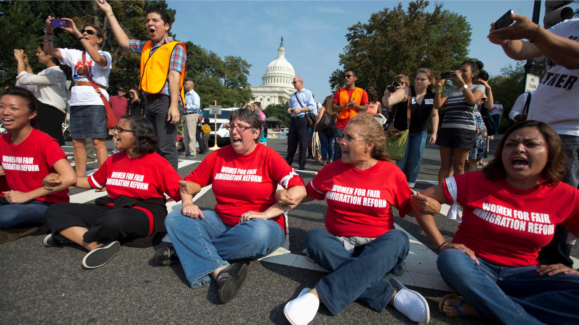 Women link arms outside the House of Representatives on Capitol Hill in Washington, Thursday, Sept. 12, 2013.