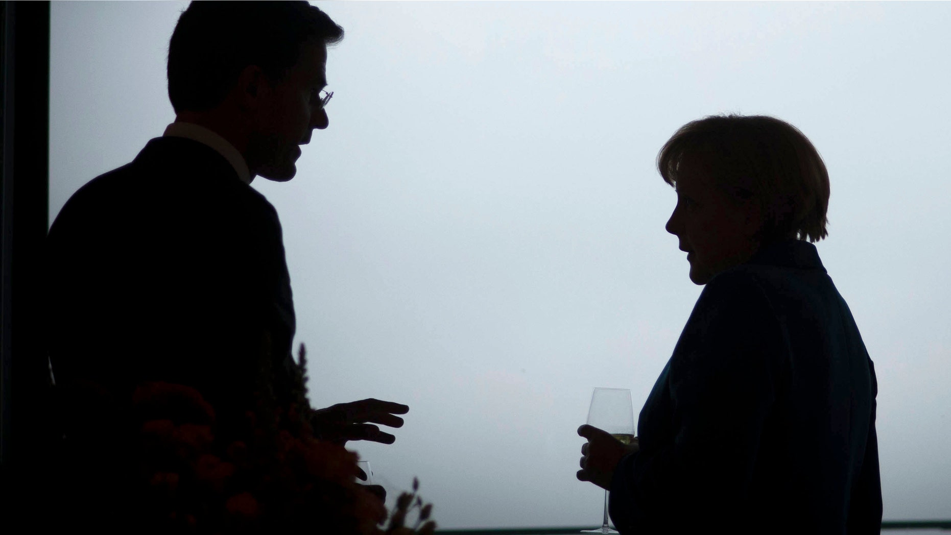 BERLIN, GERMANY - JUNE 20: In this photo provided by the German Government Press Office (BPA), German Chancellor Angela Merkel talks with the Dutch Prime Minister Mark Rutte (L) ahead of a working dinner at the Chancellery on June 20, 2012 in Berlin, Germany. Merkel told a joint press conference held with Rutte that while bailout schemes proposed to aid the Eurozone crisis include options to purchase state debt through the secondary bond market, this was not under discussion and was "purely theoretical". (Photo by Guido Bergmann - Pool/Bundesregierung-Pool via Getty Images)