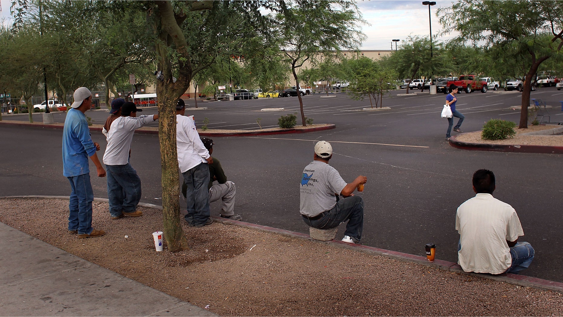 PHOENIX - JULY 26: Immigrants from Mexico and Central America await day labor work on a curbside near a Home Depot July 26, 2010 in Phoenix, Arizona. Arizona's new immigration enforcement law SB 1070 is due to go into effect Thursday and has caused widespread fear in the state's Latino community that Hispanics will be racially profiled by local police. In addition to criminalizing immigration status on a state level, the provision also makes it a crime for undocumented immigrants to "apply for work, solicit work in a public place or perform work as an employee or independent contractor in this state." (Photo by John Moore/Getty Images)