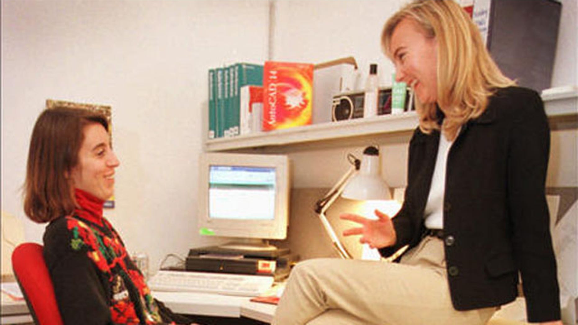 Autodesk employees Jackie Pierce, right, and Nancy Murray talk at work while Norby, the golden labrador, sleeps Dec. 17, 1997, in San Rafael, Calif. The relaxation of work rules, such as allowing a pet to accompany an employee to work, is attracting workers to more flexible companies like Autodesk. (AP Photo/Ben Margot)