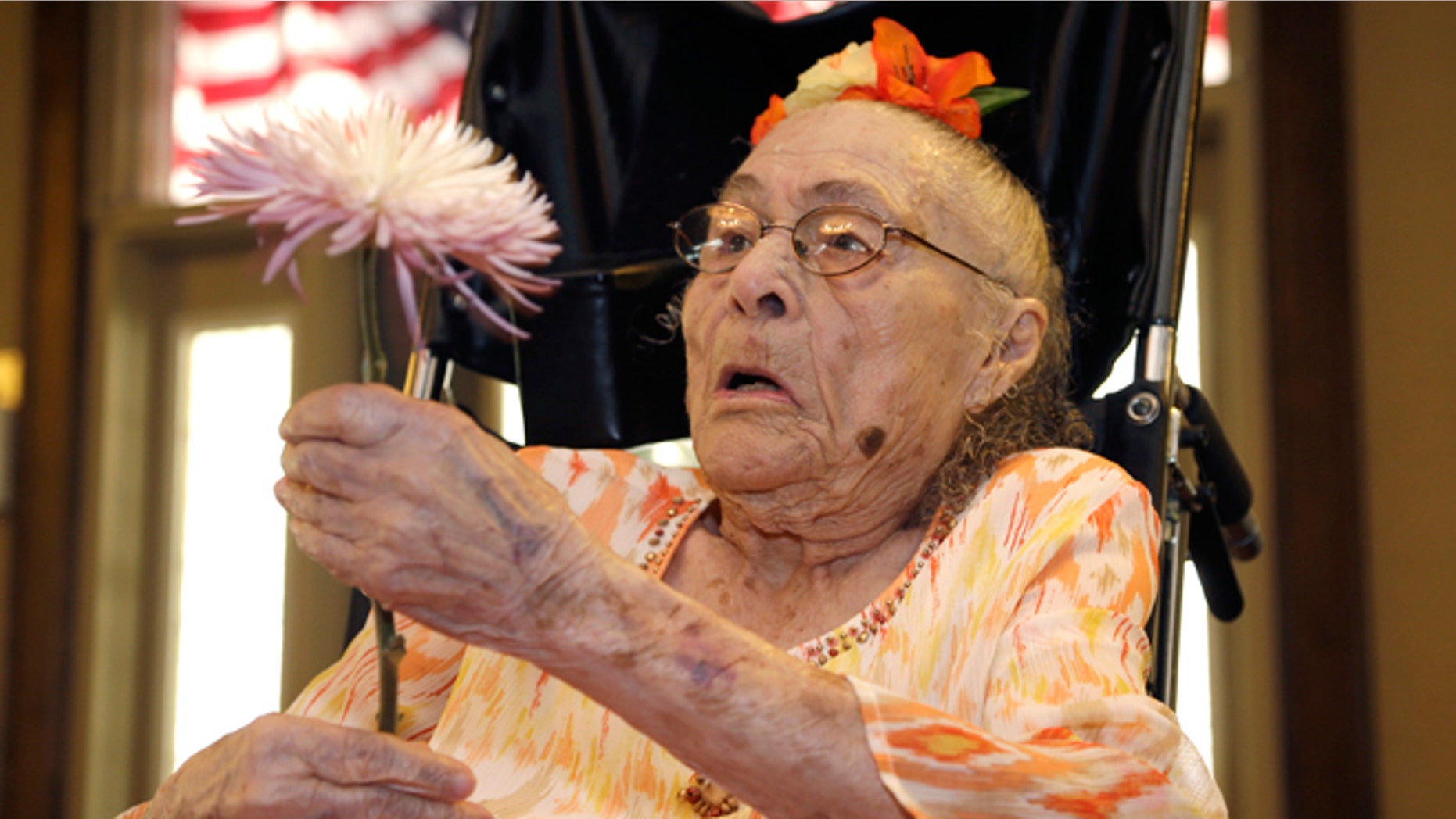 July 3, 2014: Gertrude Weaver holds a flower given to her a day before her 116th birthday at Silver Oaks Health and Rehabilitation Center in Camden, Ark.