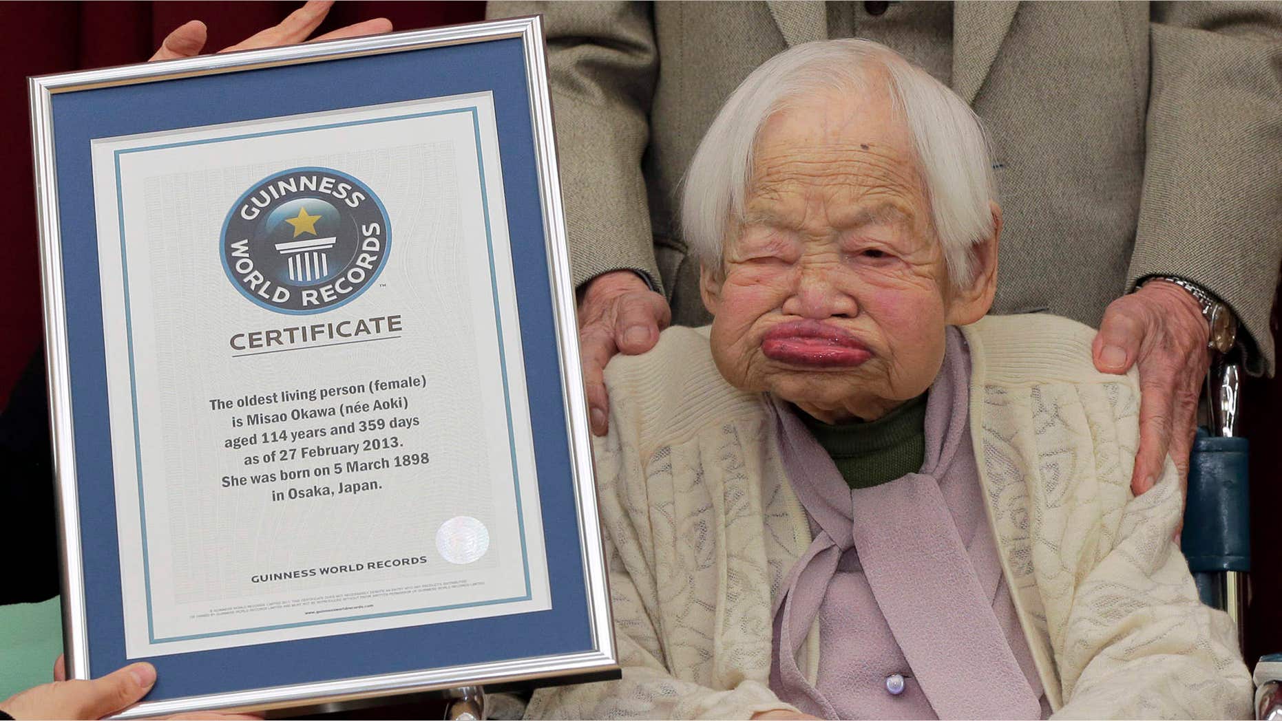 Feb. 27, 2013: Japan's Misao Okawa, then 114, poses with the certificate of the world's oldest woman, which was presented to her by Guinness World Records Japan Country Manager Erika Ogawa, unseen, at a nursing home in Osaka, western Japan.