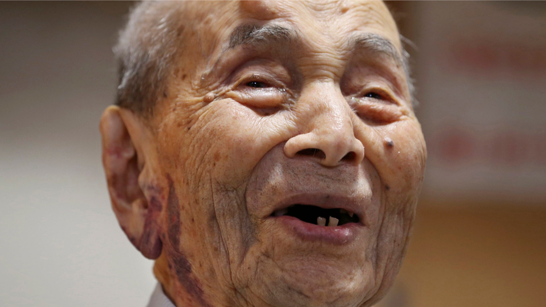 FILE - In this Aug. 21, 2015 file photo, Yasutaro Koide smiles upon being formally recognized as the world's oldest man by the Guinness World Records at a nursing home in Nagoya, central Japan. (AP Photo/Koji Sasahara, File)