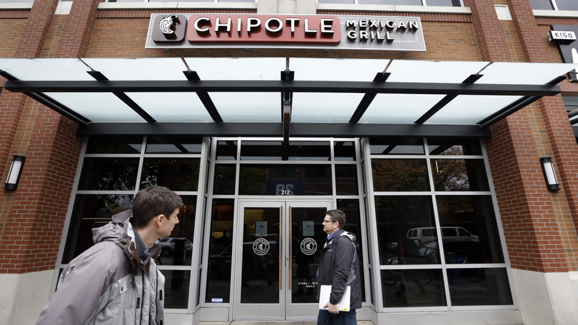 Pedestrians walk past a closed Chipotle restaurant Nov. 9, 2015, in Seattle. The Mexican Grill shuttered over 40 Pacific Northwest locations in the wake of an E.Coli outbreak.