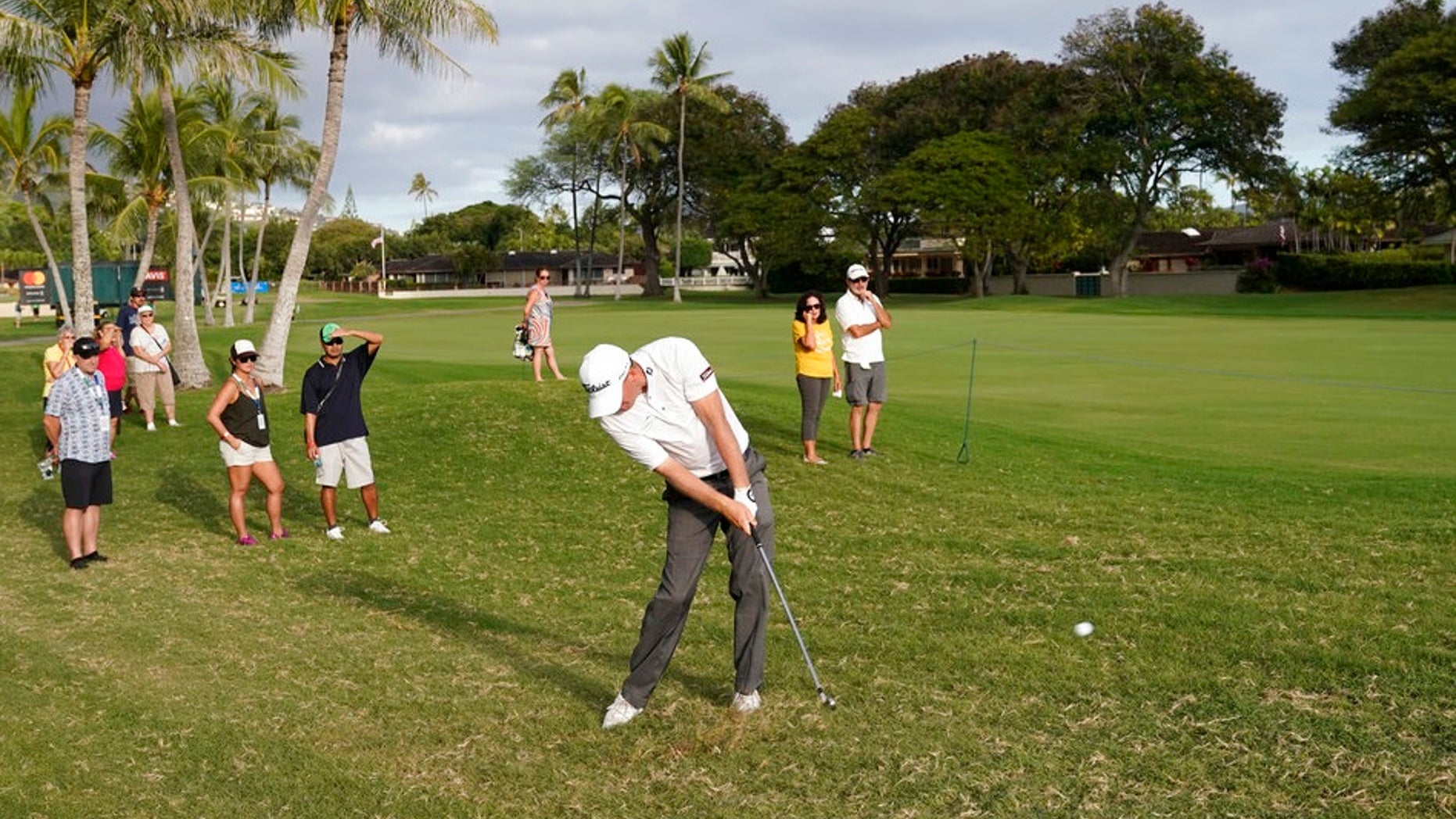 Tom Hoge, center, hits his ball out of the rough back into play on the 16th fairway during the third round of the Sony Open golf tournament, Saturday Jan. 13, 2018, in Honolulu. (AP Photo/Marco Garcia)