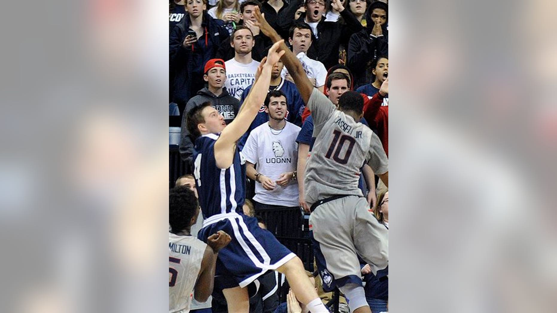 Yale's Jack Montague, left, shoots a game winning three-point shot over Connecticut's Sam Cassell Jr. (10) during the second half of Yale's 45-44 upset victory in an NCAA college basketball game in Storrs, Conn., on Dec. 5, 2014.