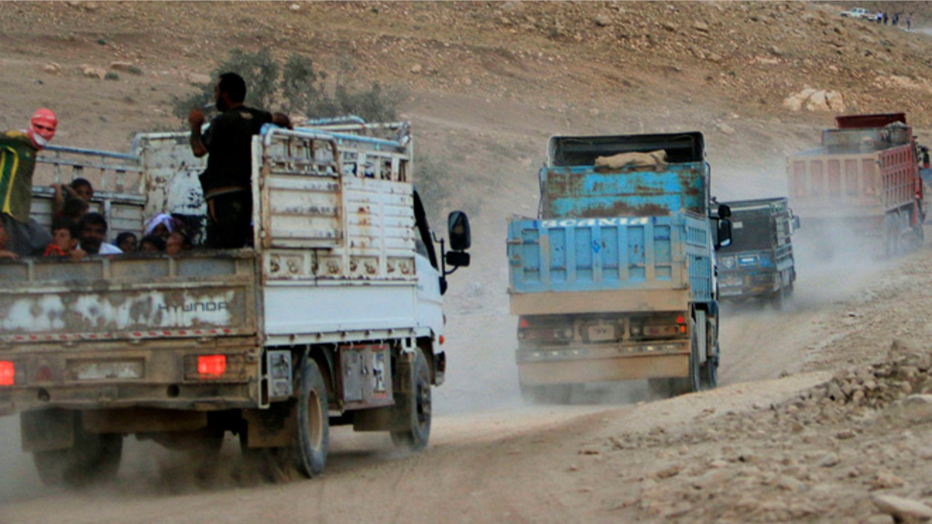 August 13, 2014: Displaced people from the Yazidi religious minority, fleeing violence from forces loyal to the Islamic State in Sinjar town, ride trucks as they are evacuated from Mount Sinjar in northern Iraq with the help of members of the Kurdish People's Protection Units (YPG), as they make their way towards Newrooz camp in Syria's al-Hasakah province.