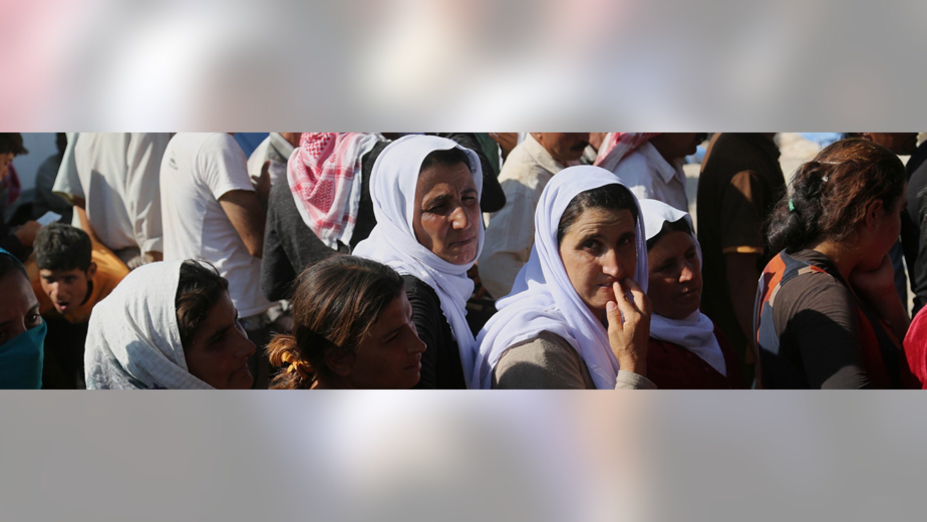 Aug. 12, 2014: Displaced Iraqis from the Yazidi community gather for humanitarian aid at Nowruz camp, in Derike, Syria.