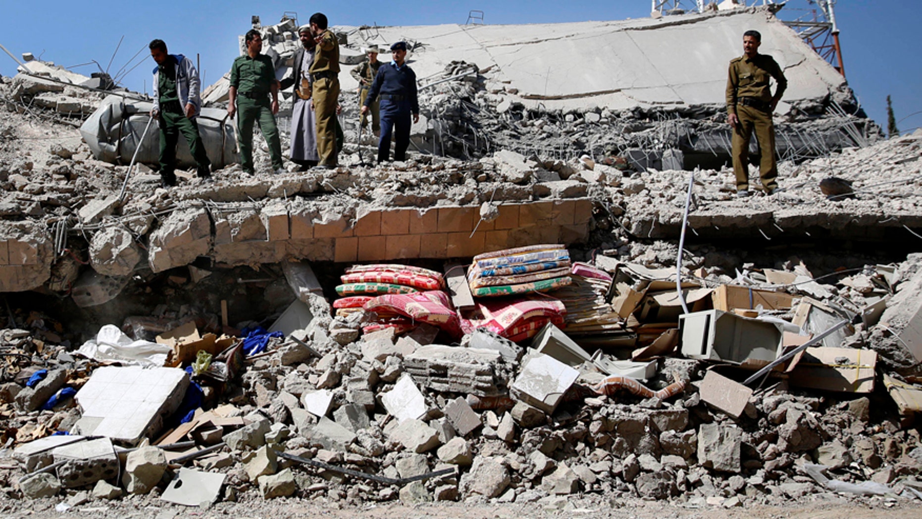 Jan. 18, 2016: Policemen gather at the site of a Saudi-led airstrike on the police headquarters in Sanaa, Yemen.