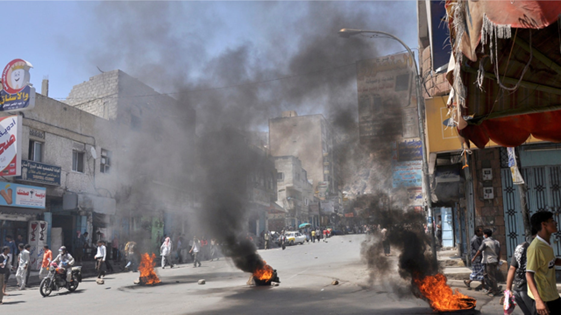 May 31: Burning tyres left by anti-government protestors as they block the road during clashes with Yemeni security forces in Taiz, Yemen.