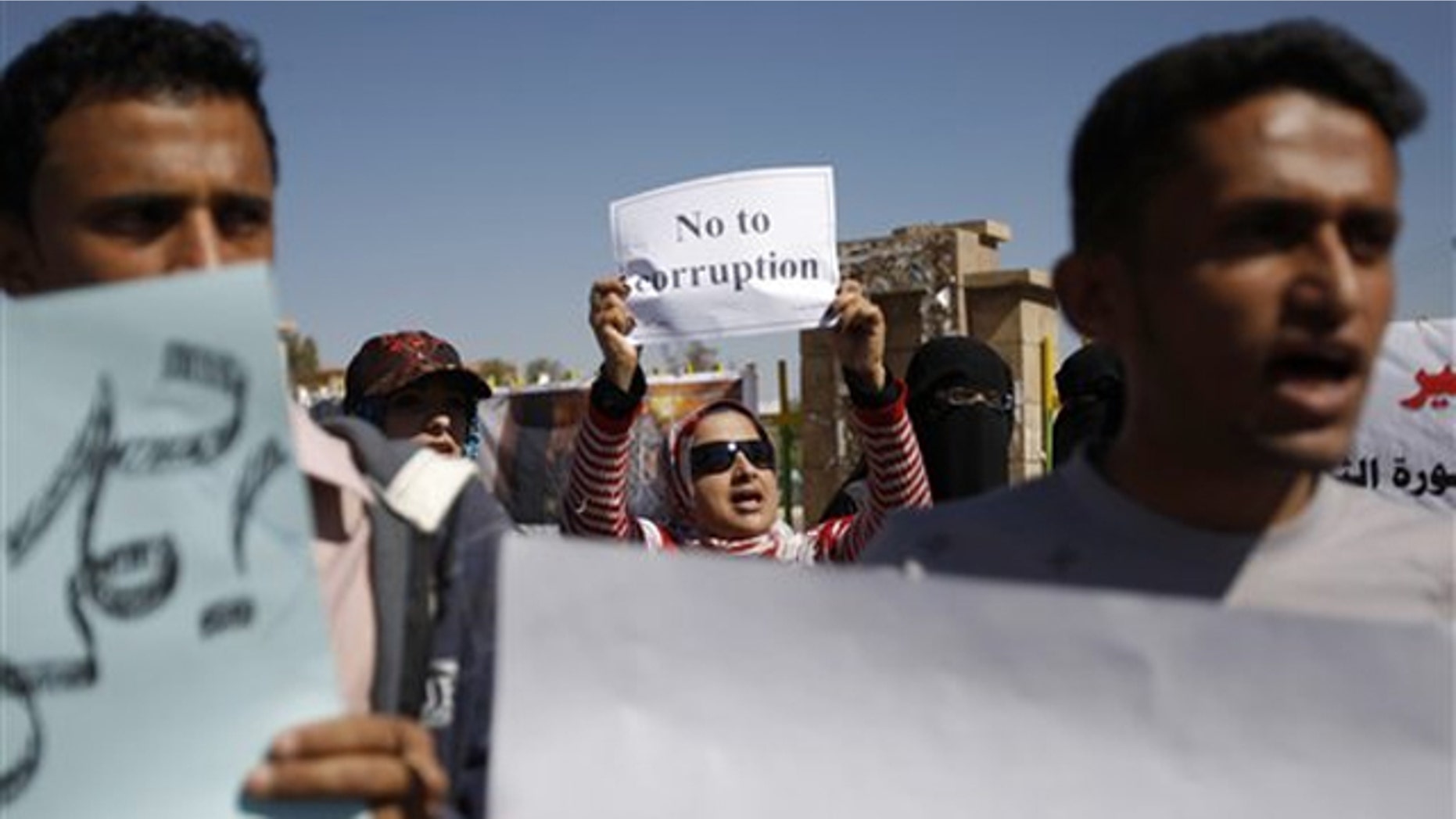 Yemeni demonstrators hold placards during an anti-government protest in Sanaa, Yemen, Feb. 10.