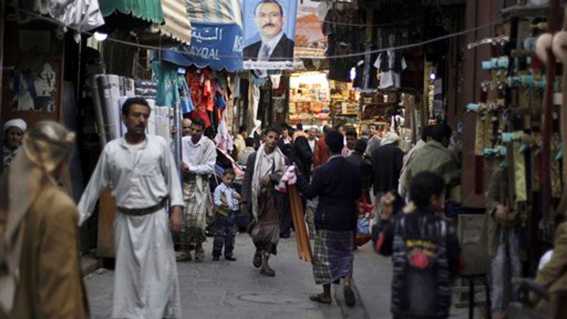 Aug. 9: People walk past vendors selling goods, beneath a poster showing Yemen's President Ali Abdullah Saleh, in a street leading to the old city of Sanaa, Yemen. The U.S. and Saudi Arabia pressured Yemen's president Ali Abdullah Saleh to stay in Saudi Arabia after he was released from a lengthy hospital stay to treat wounds suffered in an assassination attempt, according to Yemeni officials.