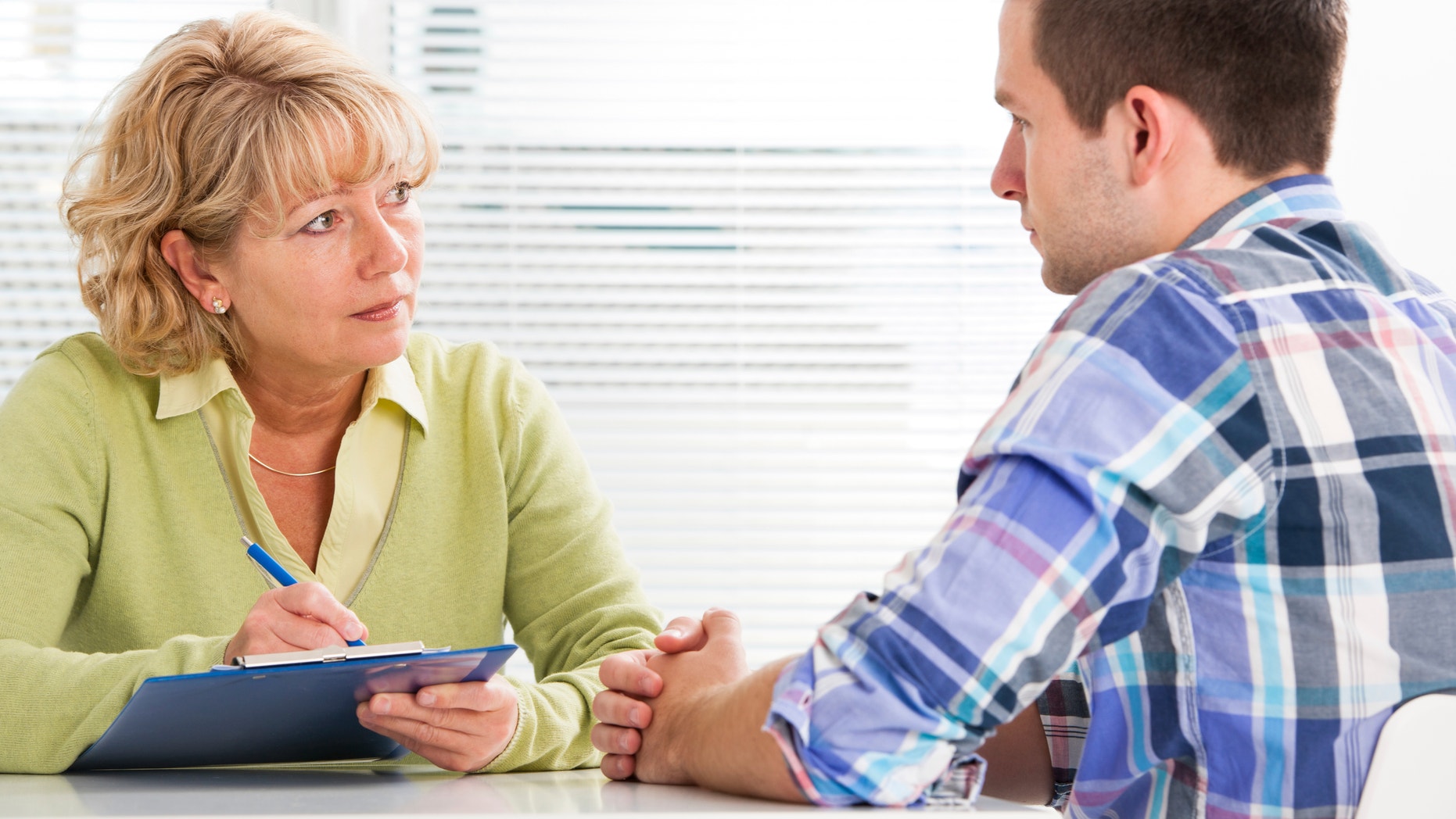 doctor talking to her male patient at office