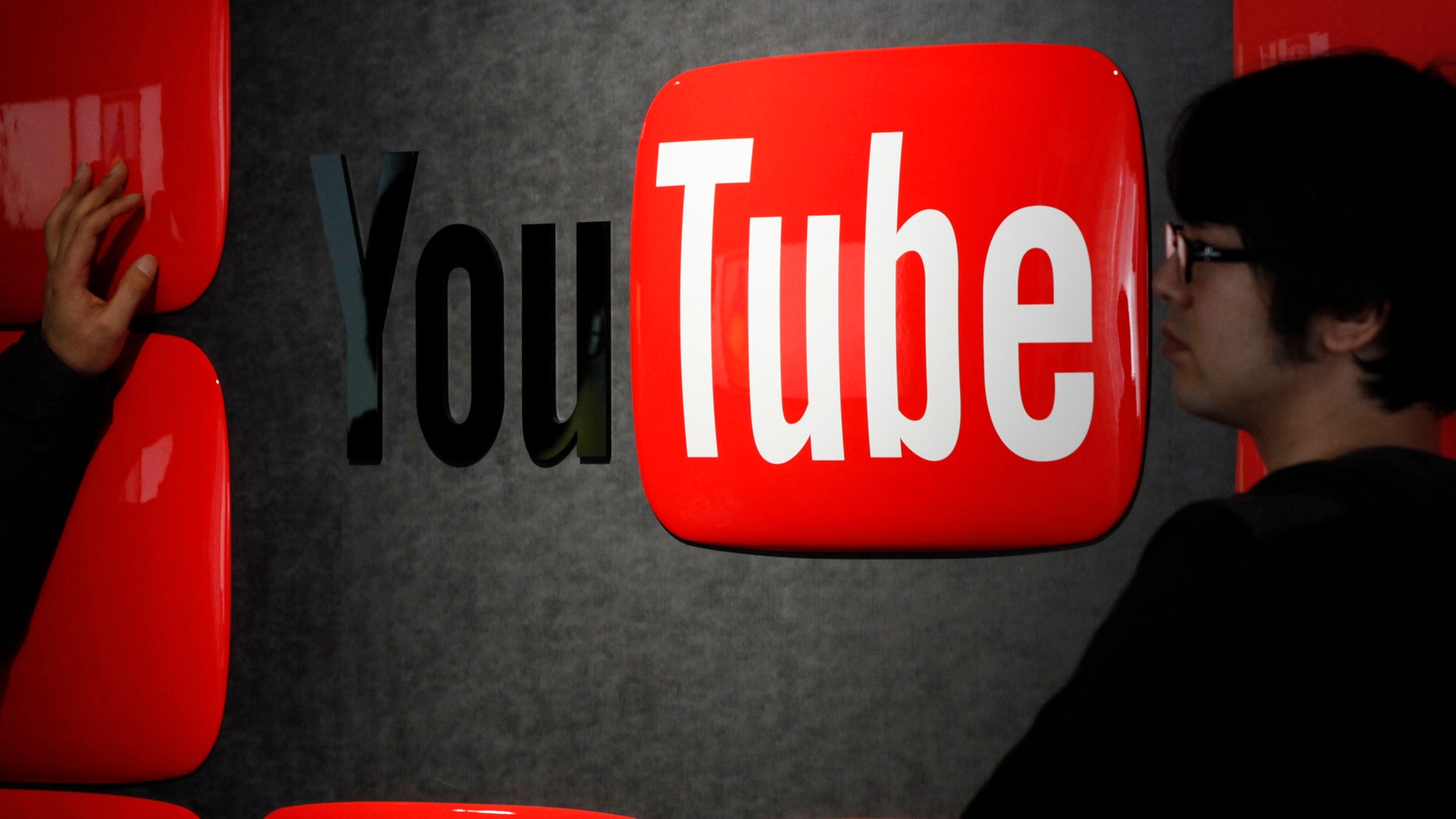 Feb. 14, 2013: Visitors stand in front of a logo of YouTube at the YouTube Space Tokyo, operated by Google, in Tokyo.