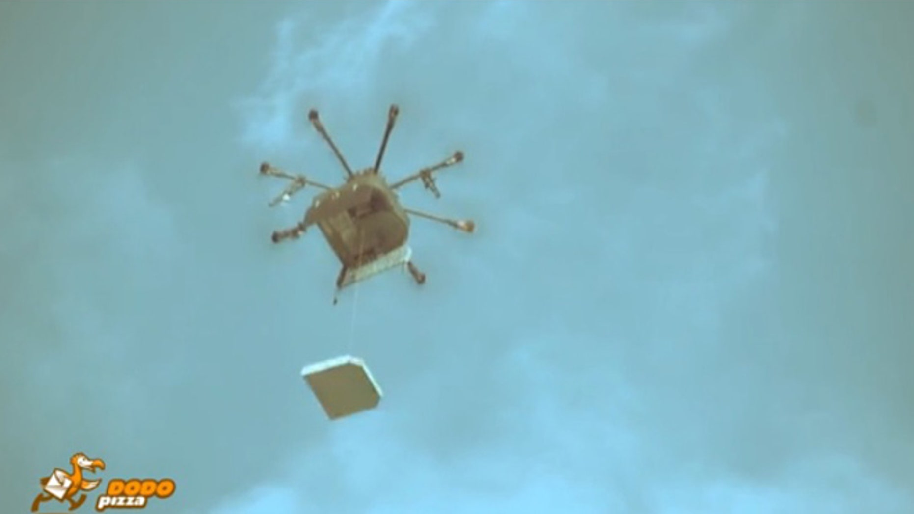 The drone lowers pizza to hungry onlookers by cable.