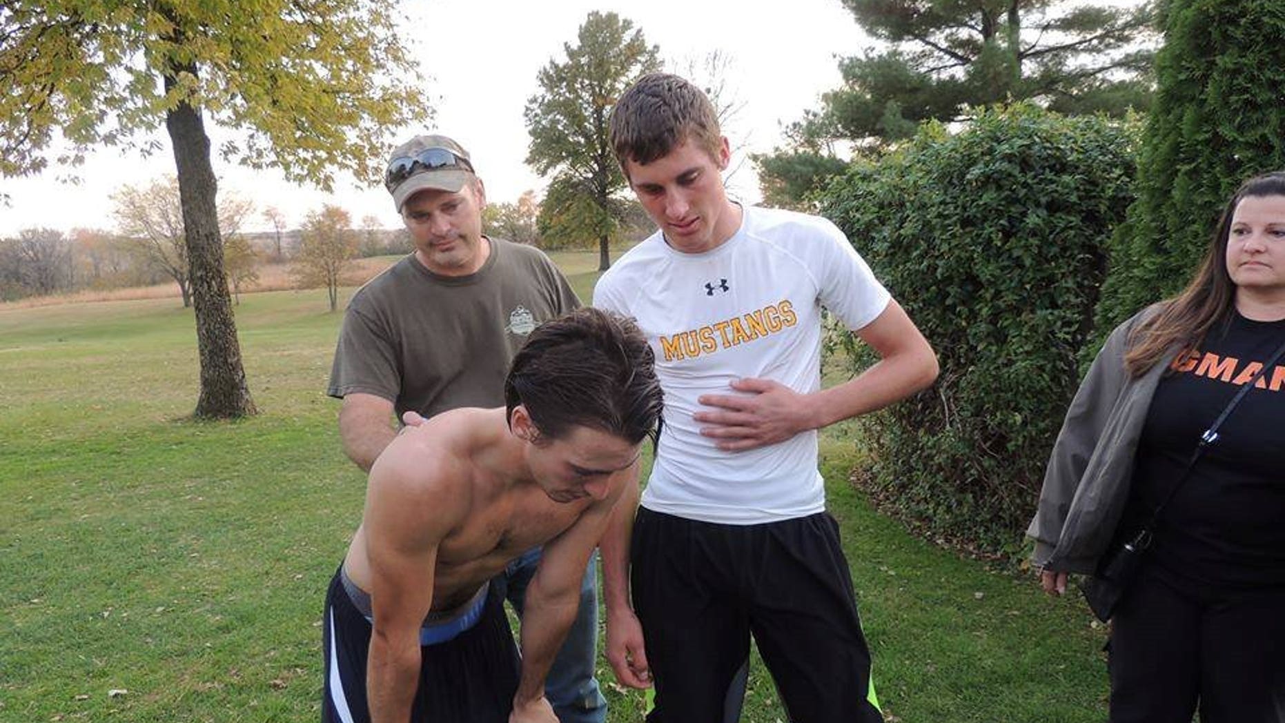 Runner Garret Hinson (left) is comforted by rival Zach Hougland (right).