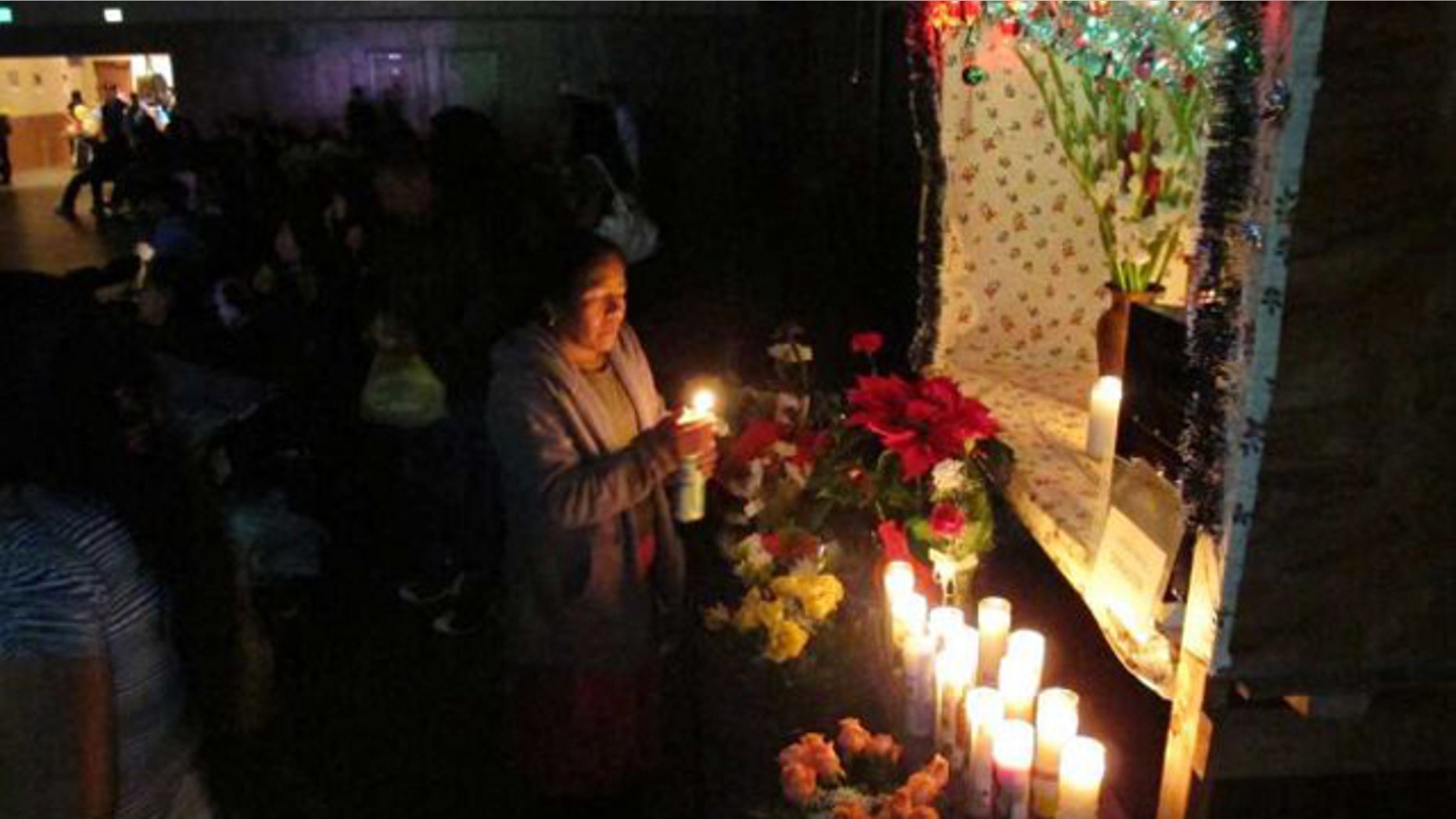 A Zapotec woman lights a candle at a mobile altar of Saint John the Evangelist in Madera, Calif. A fiesta held in the name of the patron saint of a village in the Mexican state of Oaxaca, is now celebrated by the indigenous migrant community in California.