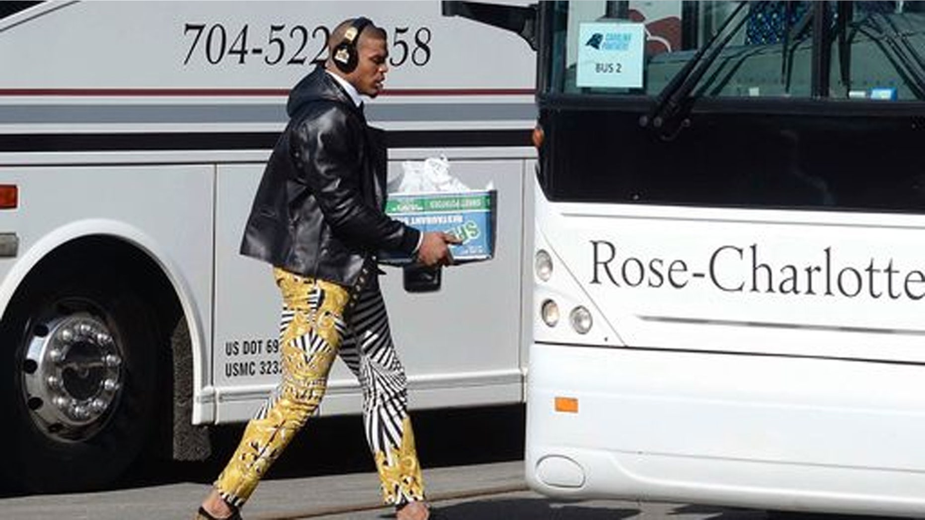 Carolina Panthers quarterback Cam Newton sports zebra-stripe pants as he moves to board a bus on his way to the airport to head to San Francisco for Super Bowl 50 against the Denver Broncos.