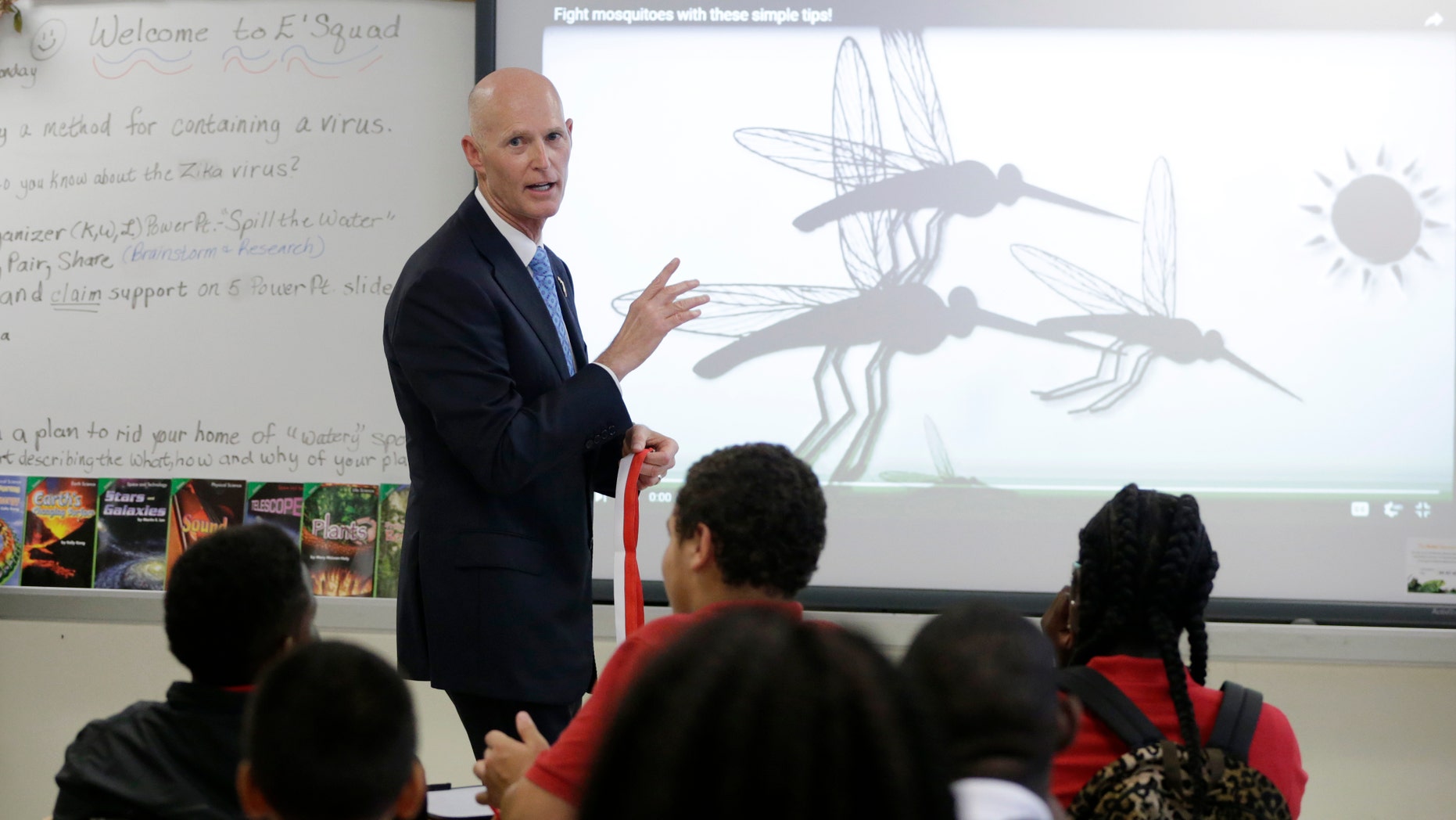 Florida Gov. Rick Scott talks with students who are studying the Zika virus, while visiting a classroom on the first day of school at the Jose de Diego Middle School, Monday, Aug. 22, 2016, in the Wynwood neighborhood of Miami. Mosquito-borne Zika cases have been found in an area of Wynwood, and in a section of Miami Beach. The CDC has issued an advisory for pregnant women to avoid travel to these two zones. (AP Photo/Lynne Sladky)