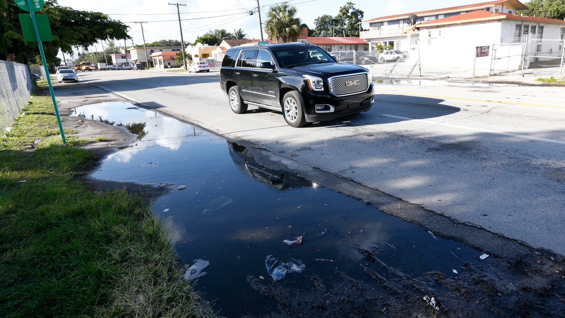 A vehicle drives past a pool of standing water where mosquitoes can breed, Friday, Oct. 14, 2016, in Miami. Thursday, Fla., Governor Rick Scott announced that the Florida Department of Health has confirmed that local transmission of the Zika virus is occurring in a new, approximately square mile area, in Miami-Dade County. (AP Photo/Wilfredo Lee)