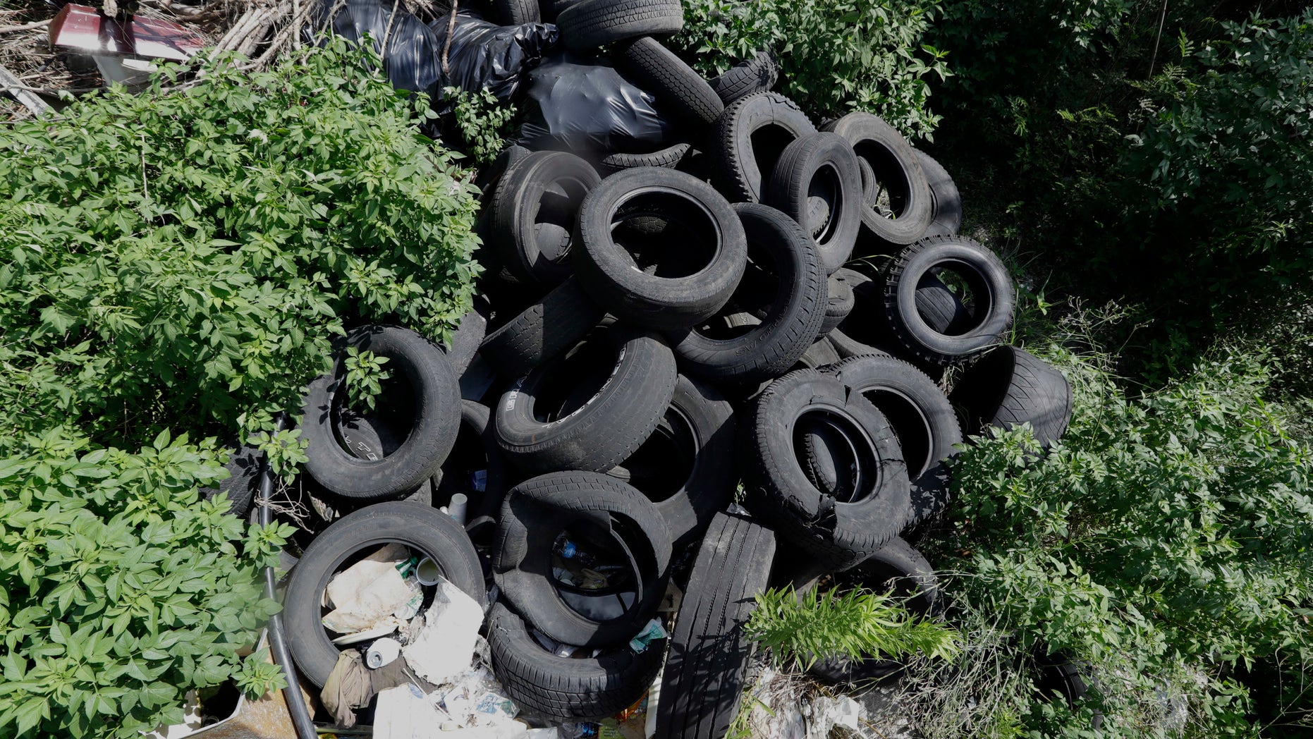 In this photo taken June 22, 2016, a pile of tires sits in a neighborhood near downtown Houston. Trash piles like this are textbook habitat for the mosquitoes that carry Zika, and one example of the challenge facing public health officials. (AP Photo/David J. Phillip)