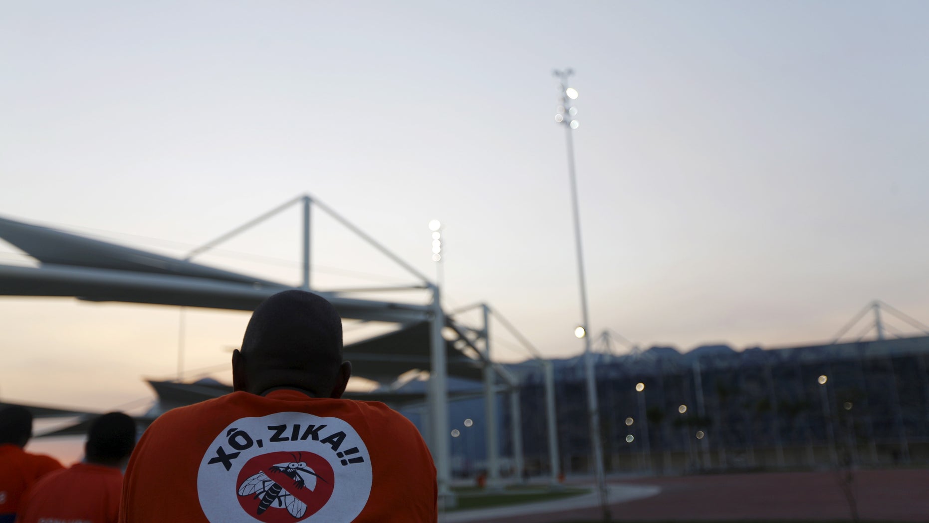 A worker from a public cleaning company wears a T-shirt that reads "Out Zika" is pictured before the inauguration ceremony of the common areas and the Live Site at the 2016 Rio Olympics park in Rio de Janeiro, Brazil, April 11, 2016.