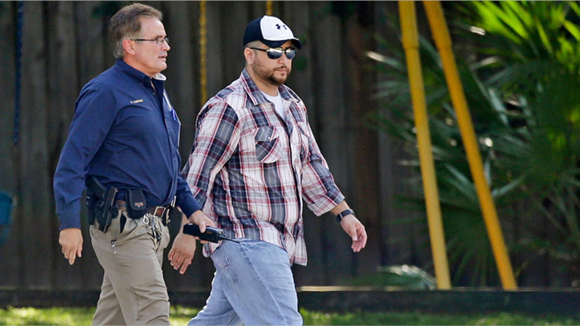 Sept. 9, 2013: George Zimmerman, right, is escorted to a home by a Lake Mary police officer in Lake Mary, Fla., after a domestic incident in the neighborhood where Zimmerman and his wife Shellie had lived during his murder trial. Zimmerman's wife says on a 911 call that her estranged husband punched her father in the nose, grabbed an iPad out of her hand and smashed it and threatened them both with a gun. Zimmerman was recently found not guilty for the 2012 shooting death of Trayvon Martin. (AP/John Raoux)