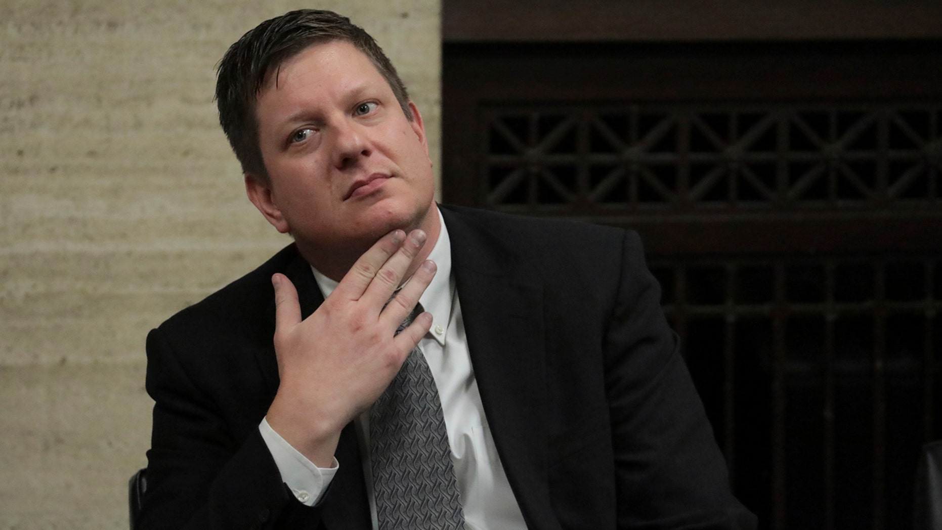 Chicago police officer Jason Van Dyke listens while lawyers appear in front of the judges' bench in front of Judge Vincent Gaughan's headquarters at the Leighton Criminal Court Building in Chicago on October 5, 2018.