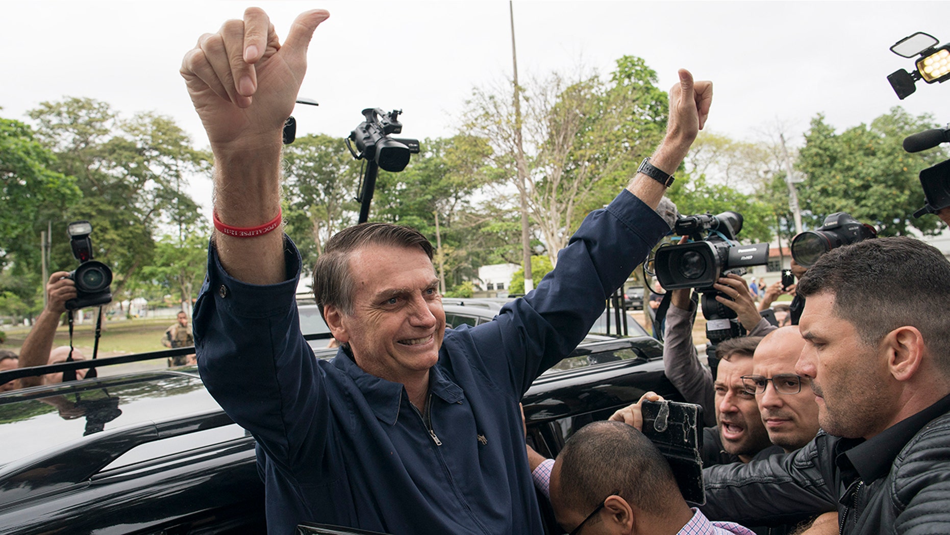 Presidential frontrunner Jair Bolsonaro, of the Social Liberal Party, flashes thumbs up to supporters after voting at a polling station in Rio de Janeiro, Brazil, Sunday, Oct. 7, 2018. (AP Photo/Leo Correa)