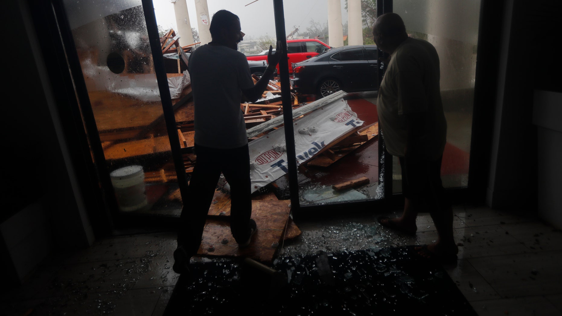 Hotel employees look at a canopy that just collapsed as Hurricane Michael passes through in Panama City Beach Fla. Wednesday Oct. 10 2018