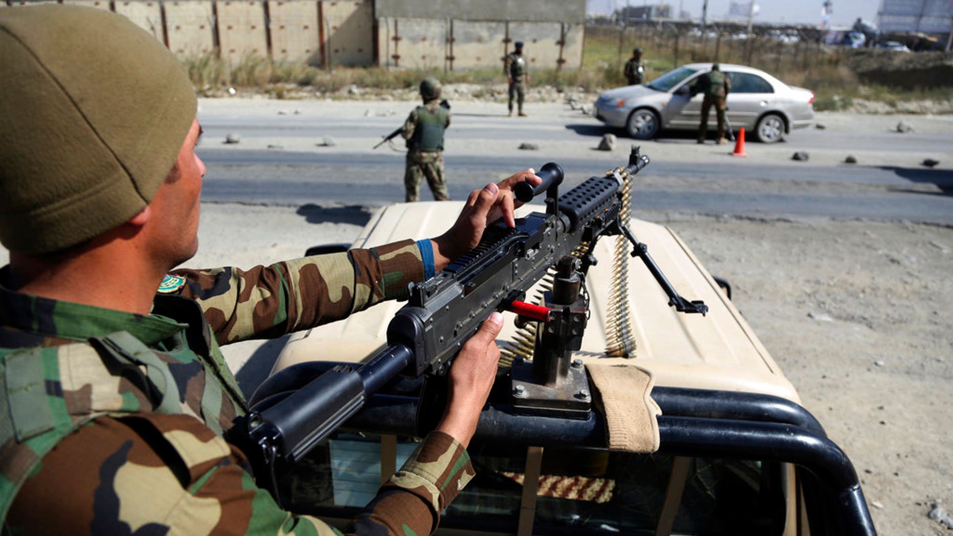 FILE: Afghan National Army soldiers search a car at a checkpoint ahead of parliamentary elections scheduled for Oct. 20, at the Independent Election Commission compound in Kabul, Afghanistan.