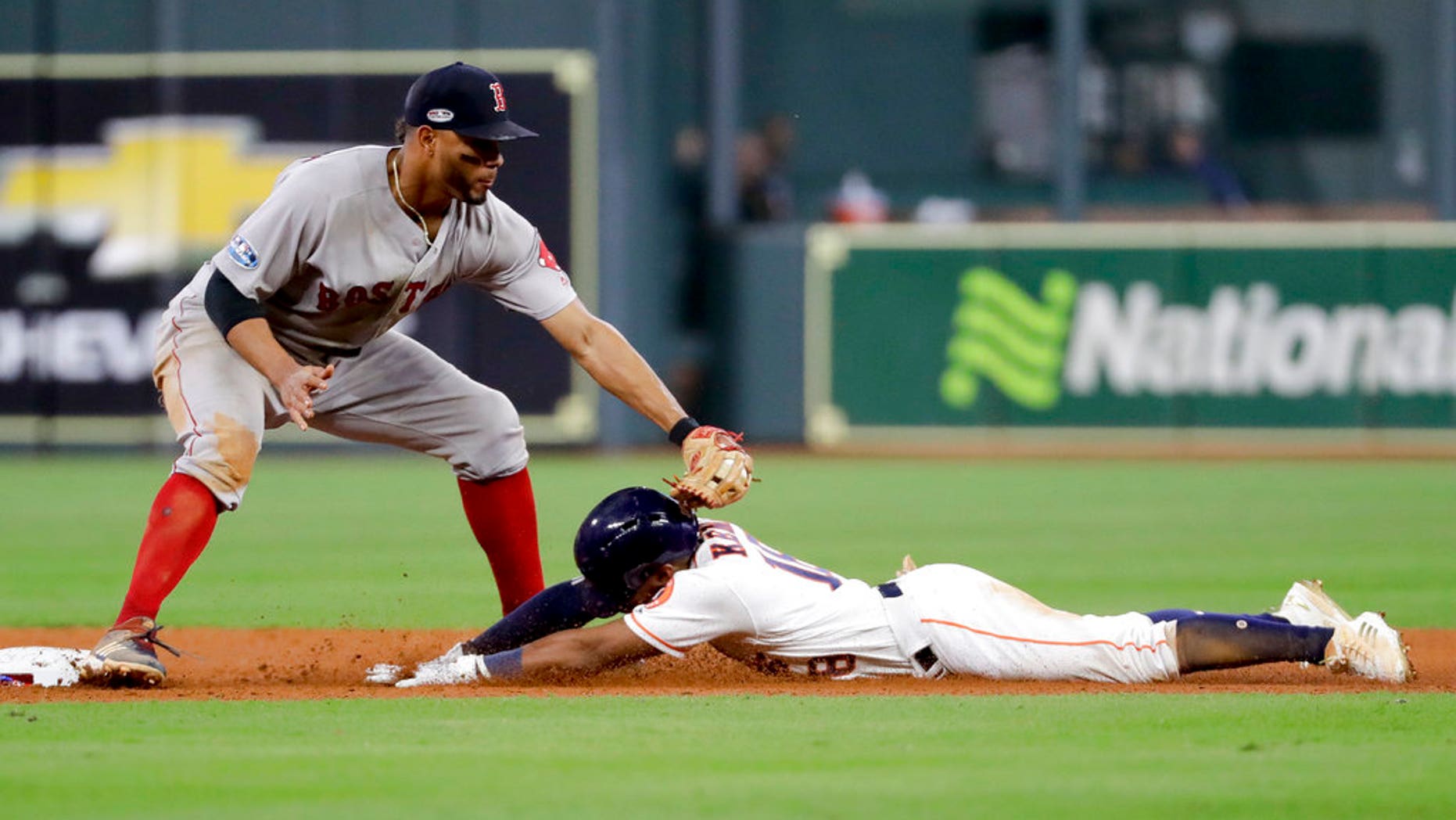 FILE: Houston Astros' Tony Kemp is tagged out at second by Boston Red Sox shortstop Xander Bogaerts during the eighth inning in Game 4 of a baseball American League Championship Series.