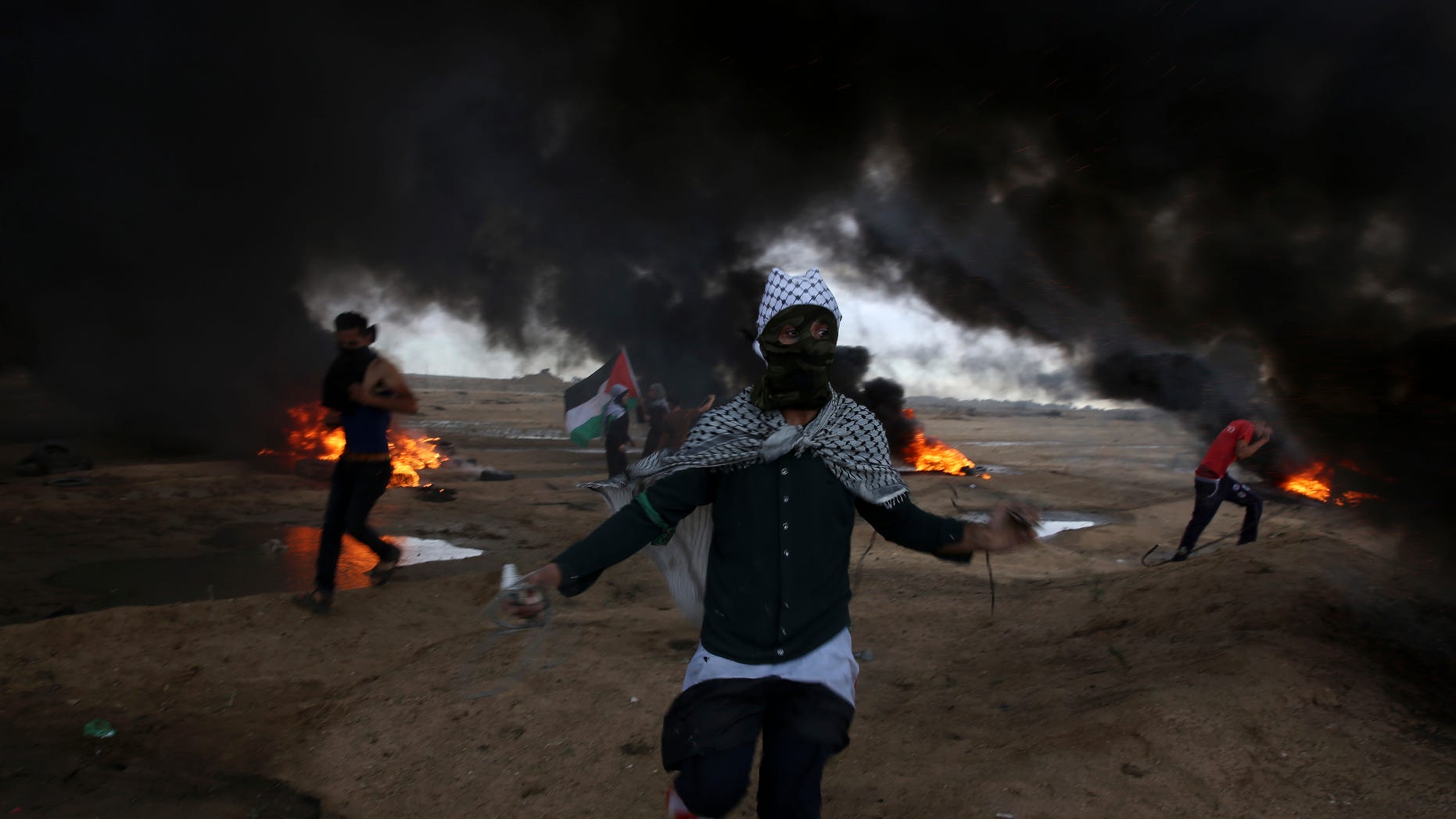 Protesters run when burn tires near the fence of the Gaza Strip border with Israel during a protest east of east of Gaza City, Friday, Oct. 26, 2018. (AP Photo/Adel Hana)