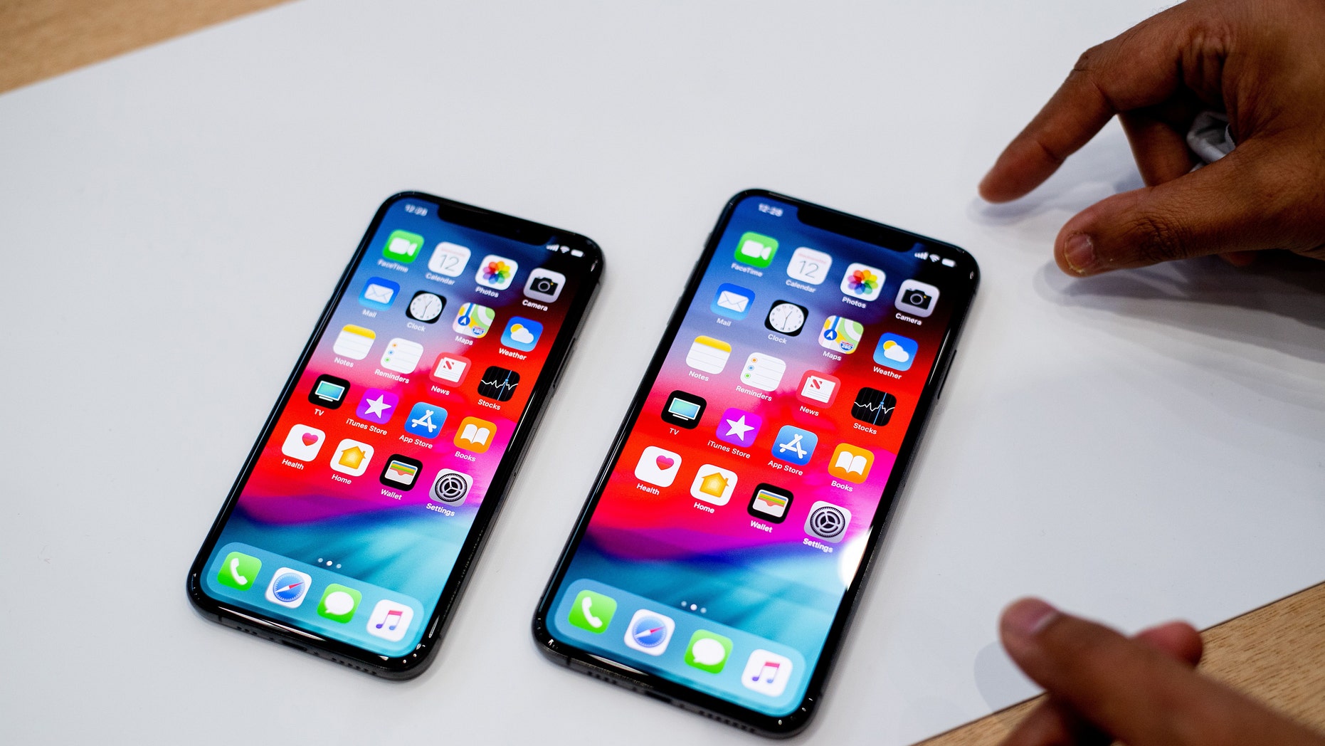 An Apple iPhone Xs Max (R) and iPhone Xs rest on a table during a launch event on September 12, 2018, in Cupertino, California.