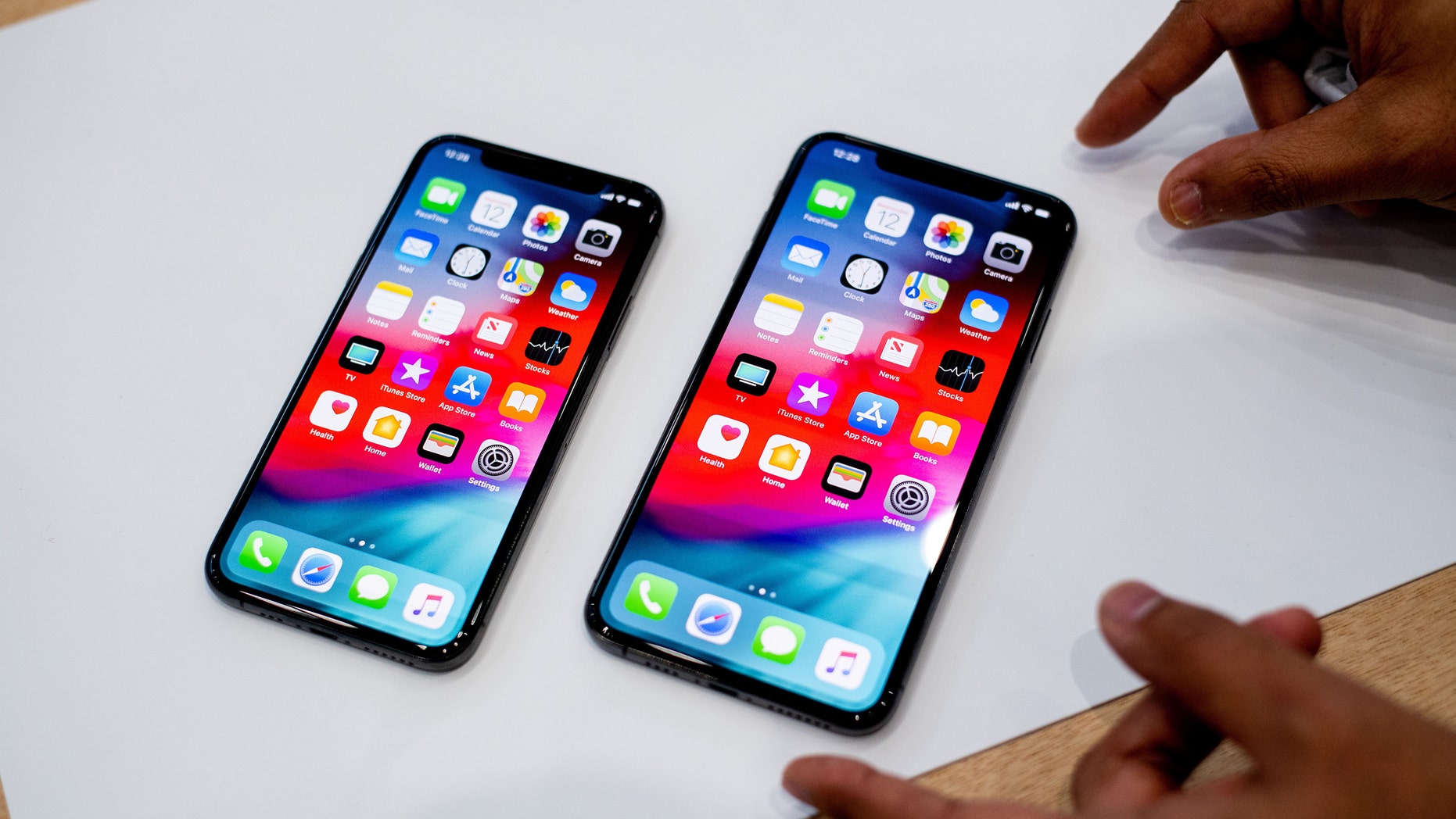 An Apple iPhone Xs Max (R) and iPhone Xs rest on a table during a launch event on September 12, 2018, in Cupertino, California.