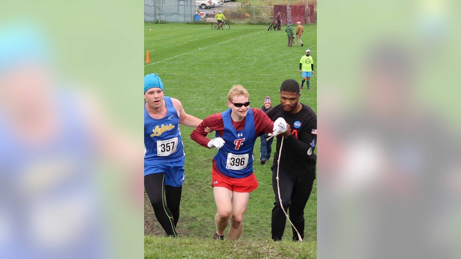 Cazenovia High School sophomore Jake Tobin, left, helps Fairport High School senior Luke Fortner, center, during a cross country race in Auburn, N.Y. Fortner, who is legally blind, fell towards the end of the race but was assisted by Tobin, and Jerry Thompson, right, his running aide.