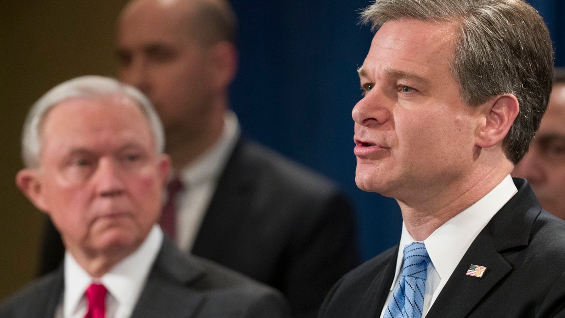 Attorney General Jeff Sessions, left, listens as FBI Director Christopher Wray speaks during a news conference about the arrest of Cesar Sayoc, 56, of Aventura, Fla., in the package bomb case, at the Department of Justice on Friday.