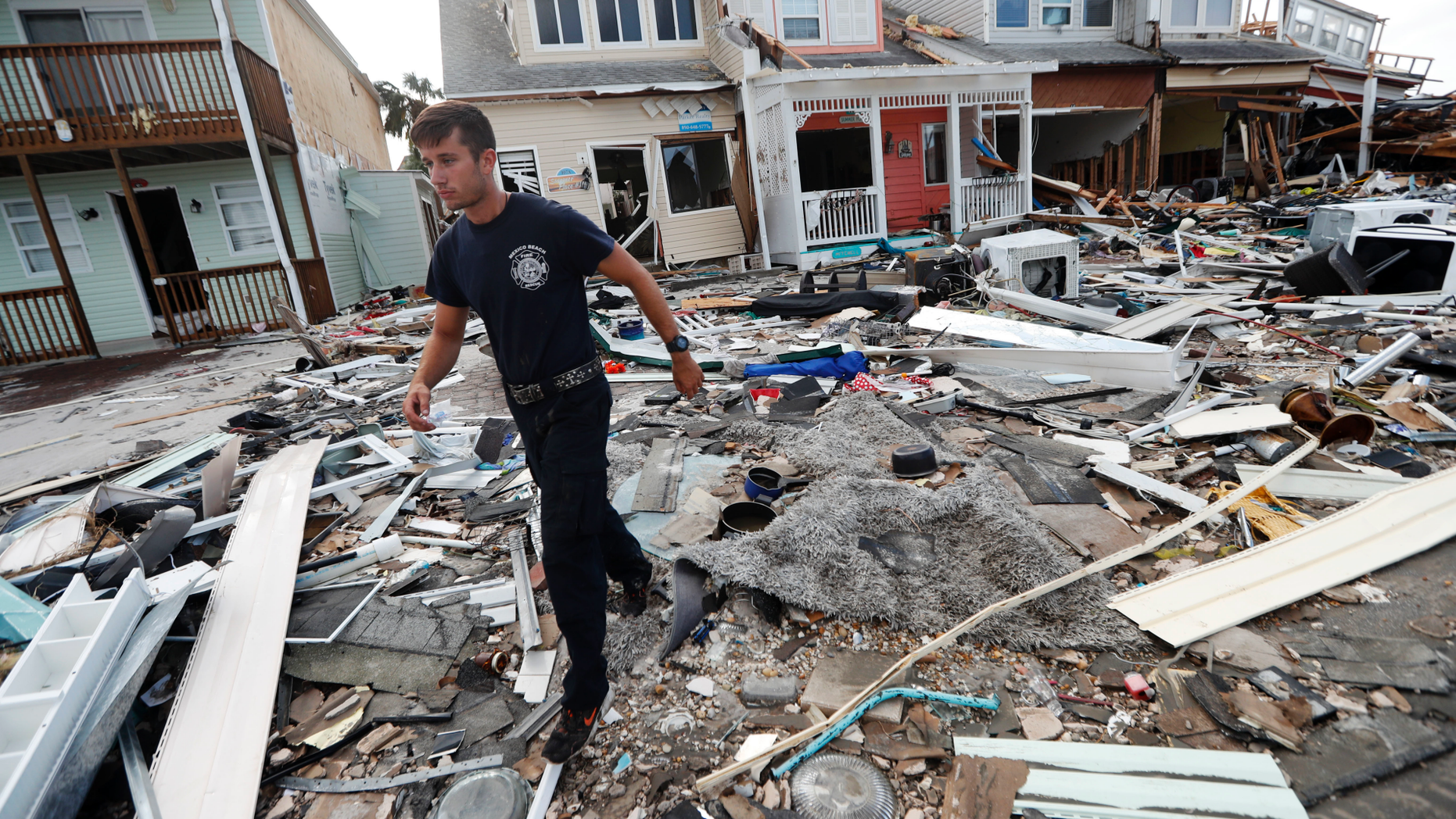 Firefighter Austin Schlarb performs a door to door search in the aftermath of Hurricane Michael in Mexico Beach, Fla., Thursday, Oct. 11, 2018. (AP Photo/Gerald Herbert)