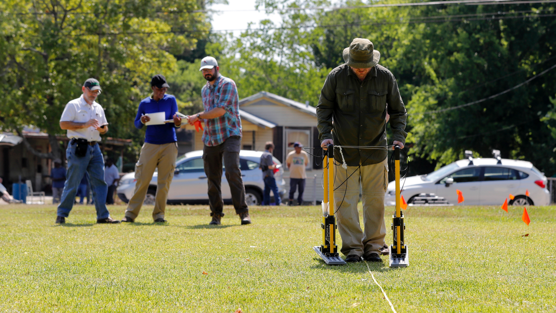 FILE - In this Thursday, May 17, 2018 file photo, Tulane University researcher Dr. Ryan Gallacher uses ground penetrating radar equipment with a team from Tulane, on a piece of land that may hold a mass grave from a Reconstruction-era racial massacre in Thibodaux, La. A suspected burial ground where the bodies of an 1887 racial massacre may have been dumped should be studied further, a scientific team suggests, Wednesday, Oct. 24, 2018. (AP Photo/Gerald Herbert, File)
